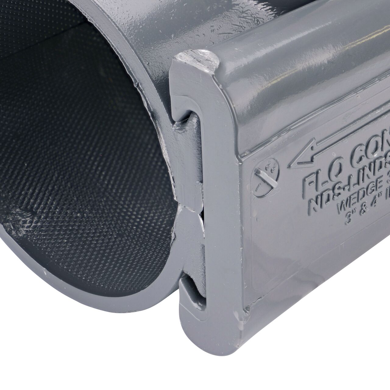 Closeup of the wedge installed securely on the NDS Clamp-It™ Rigid PVC Saddle with 1-1/2 in. FPT connection on top (NDS 443015) for 3 in. PVC pipe