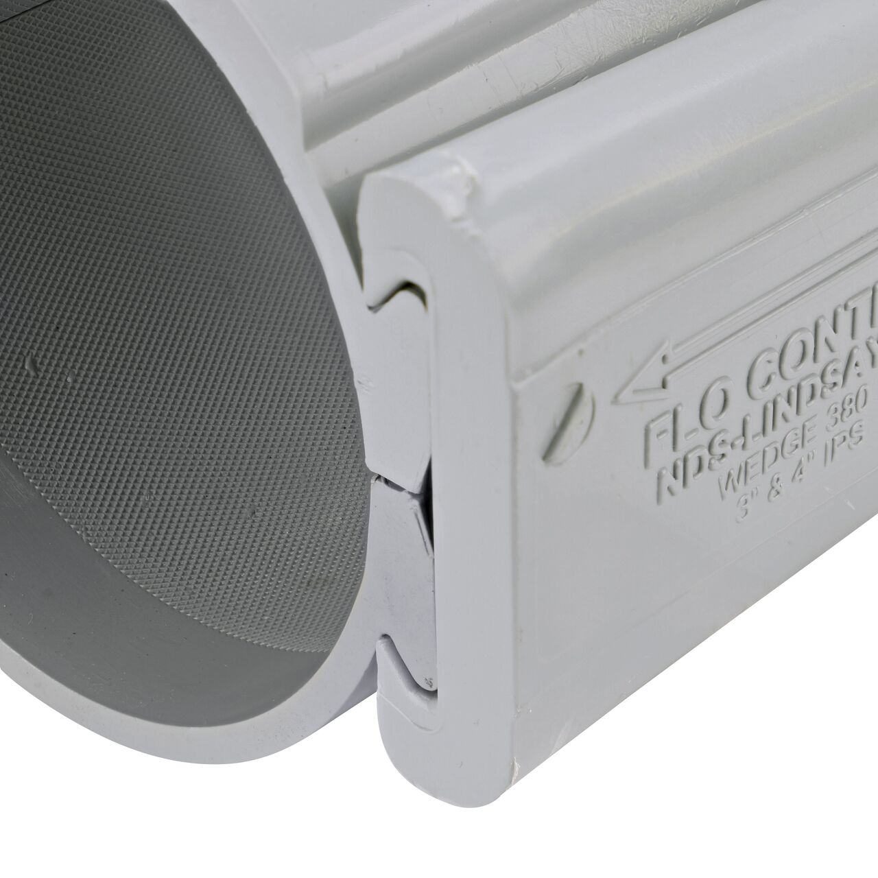 Closeup of the wedge installed securely on the NDS Clamp-It™ Rigid PVC Saddle with 1 in. slip connection on top (NDS 454010) for 4 in. PVC pipe