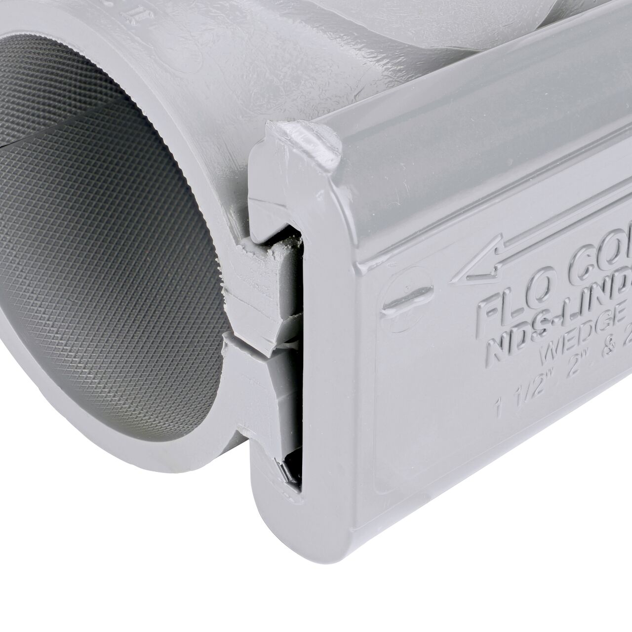 Closeup of the wedge installed securely on the NDS Clamp-It™ Rigid PVC Saddle with 1 in. slip connection on top (NDS 432010) for 2 in. PVC pipe