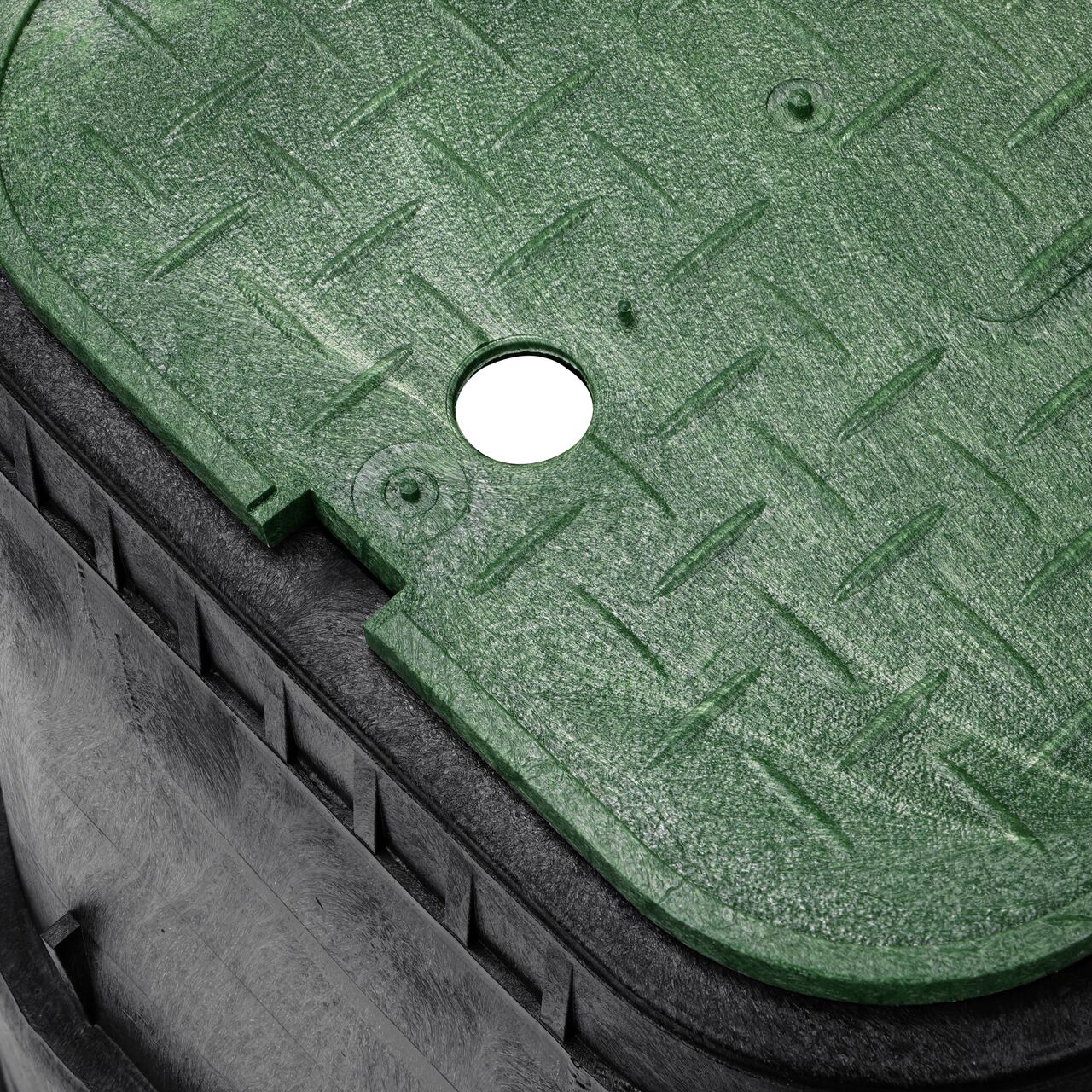 Closeup view of the pipe hole on the Black NDS 14 in. X 19 in. Rectangular Standard Series Meter Box (NDS D1800-OLSG) for water and irrigation pipe connections