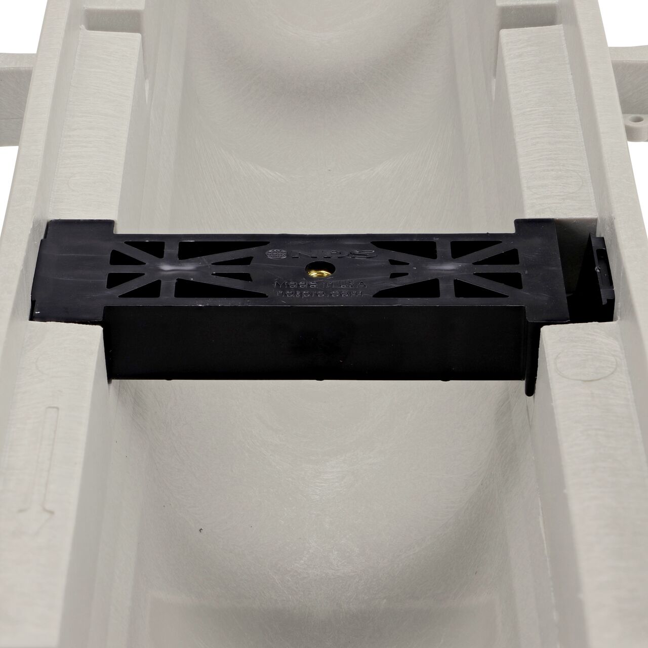 Closeup view of the grate locking system on the NDS Dura Slope Channel Drain, which locks grate to the integral frame