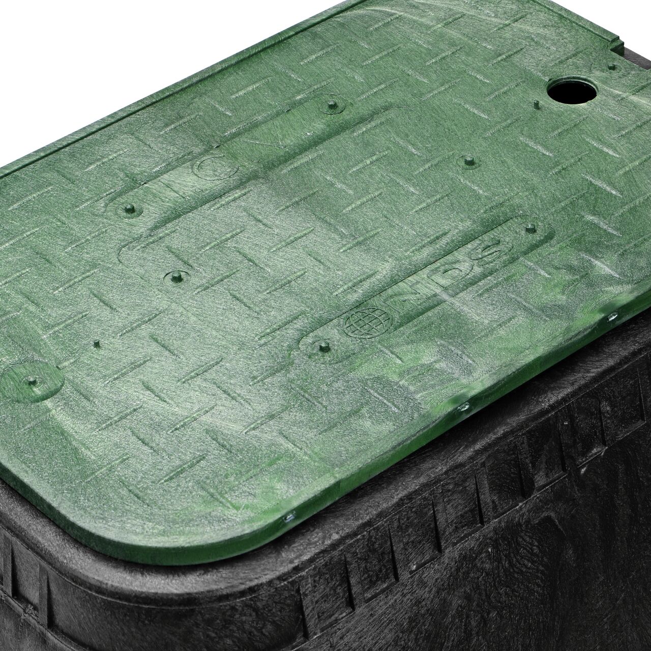 Closeup view of the pipe hole on the Black NDS 14 in. X 19 in. Rectangular Standard Series Meter Box (NDS D1800-OLSG) for water and irrigation pipe connections