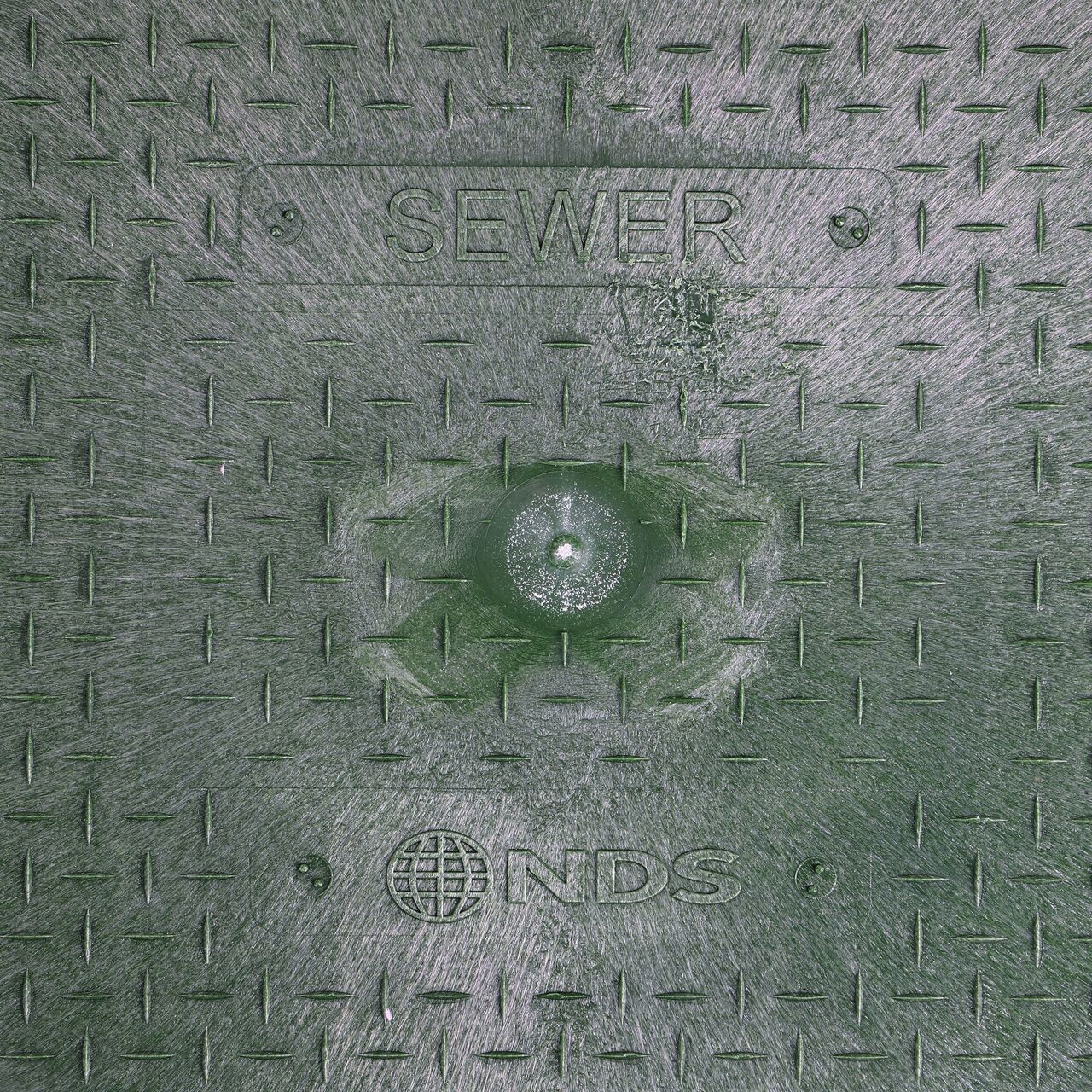 Closeup view of the Sewer markings on the Green Sewer Drop-in cover for the NDS 14 in. X 19 in. Rectangular Standard Series Meter Cover (NDS D1200-DISGSWRL)