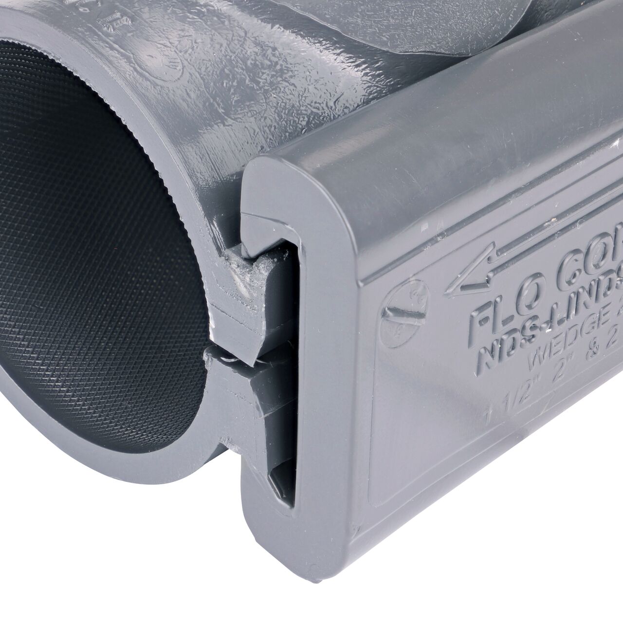 Closeup of the wedge installed securely on the NDS Clamp-It™ Rigid PVC Saddle with 1 in. FPT connection on top (NDS 422010) for 2 in. PVC pipe