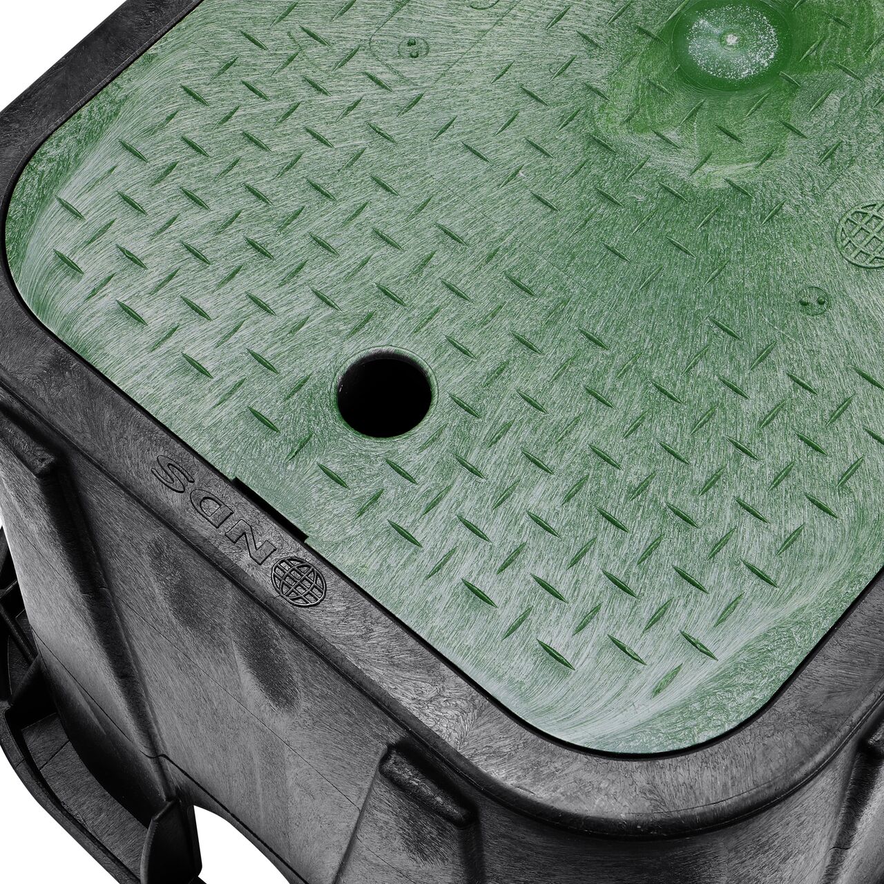 Closeup view of the pipe hole on the Black NDS 14 in. X 19 in. Rectangular Standard Series Meter Box (NDS D1200-DISGSWR) for water and irrigation pipe connections