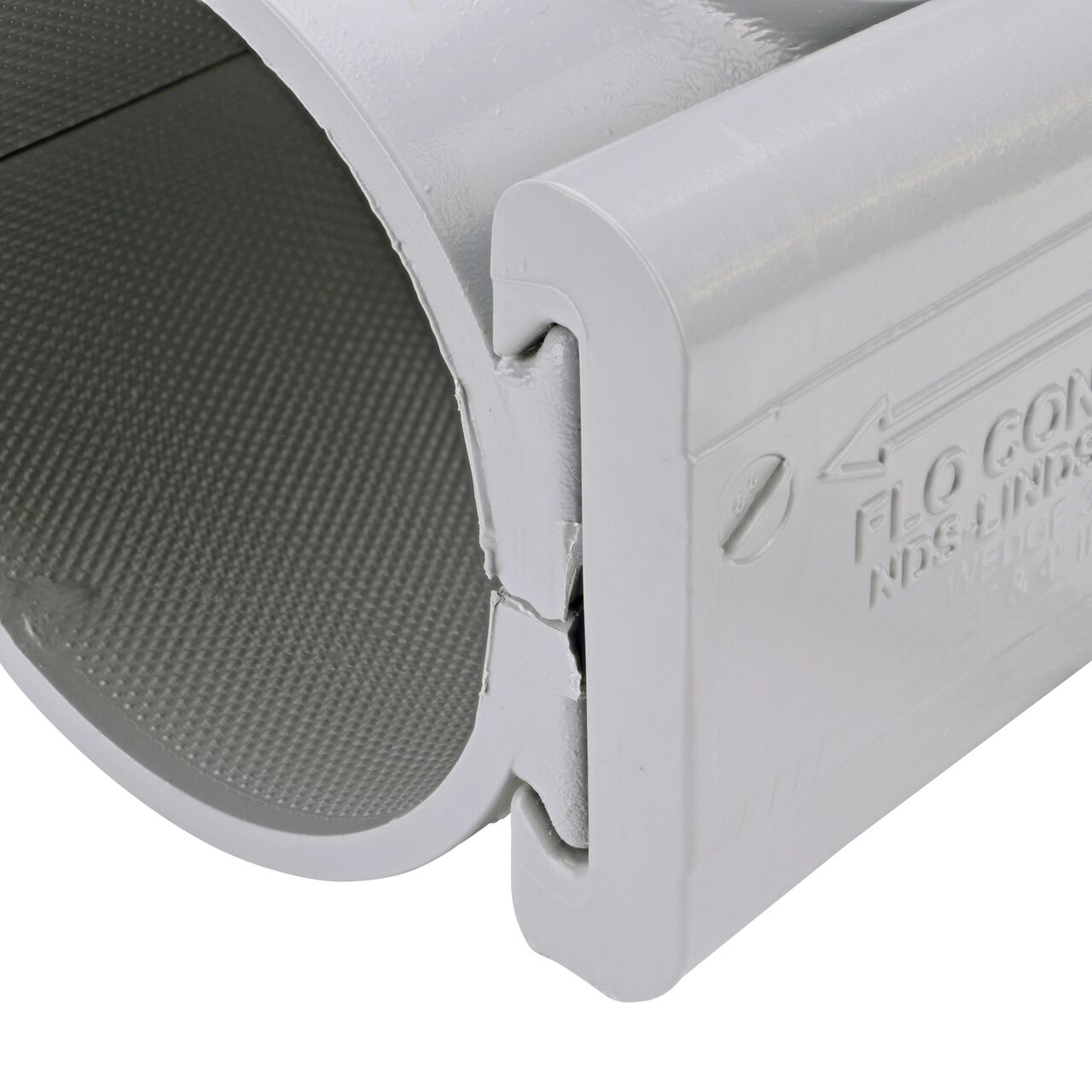 Closeup of the wedge installed securely on the NDS Clamp-It™ Rigid PVC Saddle with 3/4 in. slip connection on top (NDS 453007) for 3 in. PVC pipe