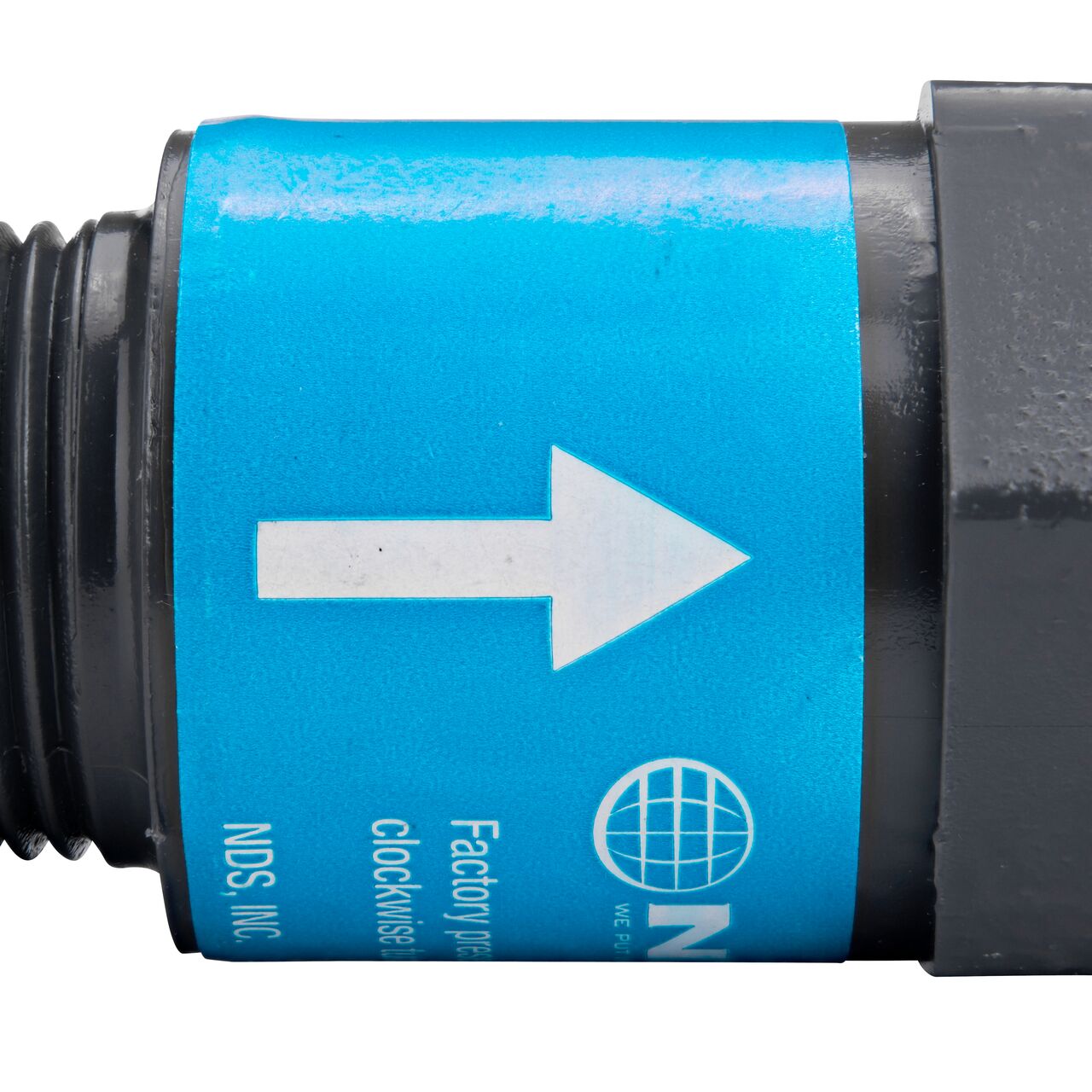 Closeup of the label marking the flow of water of the NDS Gray 3/4 in. IPS MPT X FPT PVC Adjustable Inline Spring Check Valve (NDS CV-0750-MF)