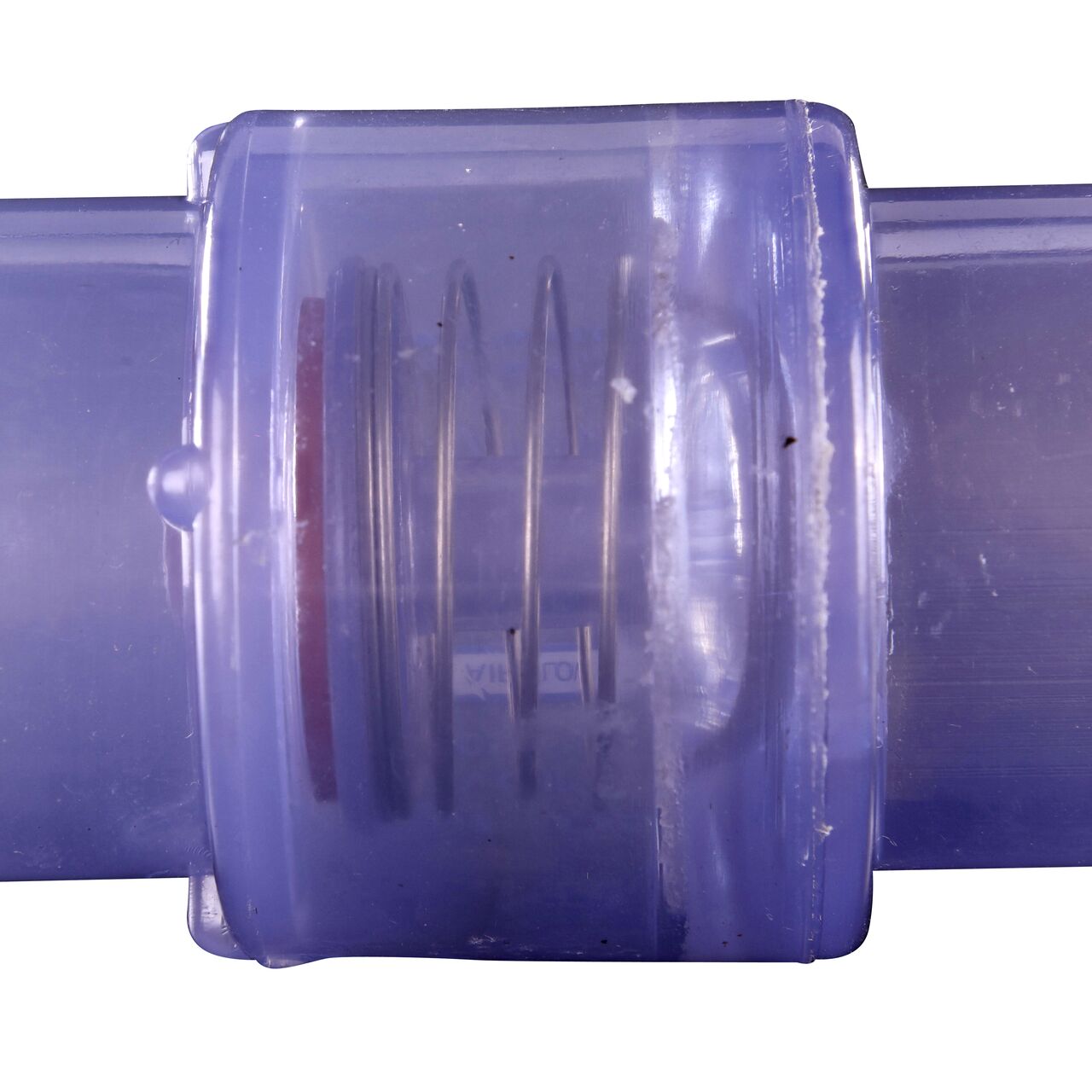 Closeup of the spring of the the 1/4 lb spring closes the flapper to prevent water from flowing the wrong direction in the NDS Clear 1 in. slip end by 1-1/4 spigot end PVC Air Check Valve (NDS 1050C10)