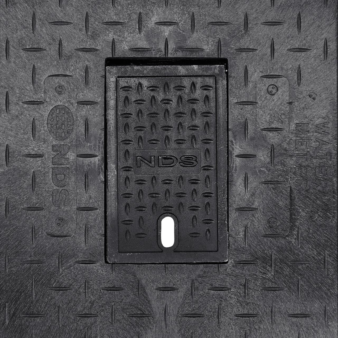 Closeup view of the Water Meter markings and Cast Iron reader door on the Black Water Meter Drop-in cover for the NDS 13 in. X 24 in. Rectangular Standard Series Meter Cover (NDS 121CDMCIF)