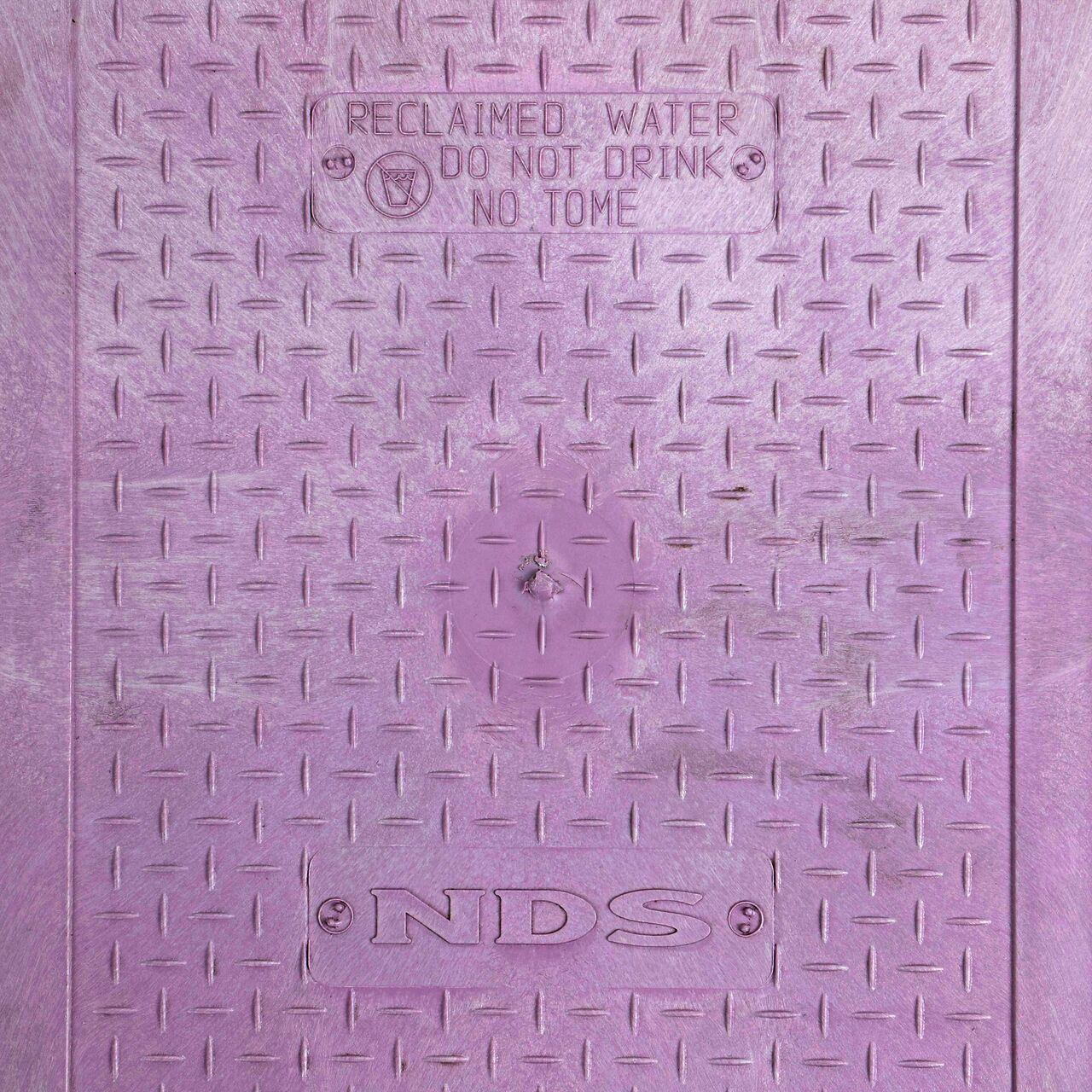 Closeup view of the Reclaimed Water markings on the Purple Reclaimed Water cover for the NDS 14 X 19 in. Rectangular Standard Series Valve Box (NDS 115TBCR)