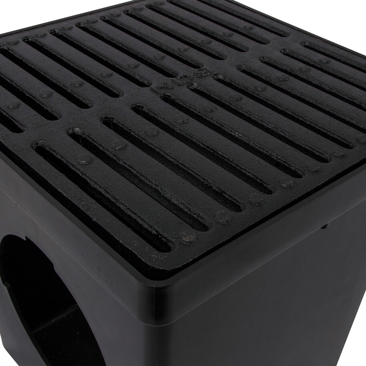 Closeup view of the 12 in. Ductile Iron Metal Grate (NDS 1213) installed on a black plastic 12 in. Catch Basin Drain with 2 Openings (NDS 1200*); retail