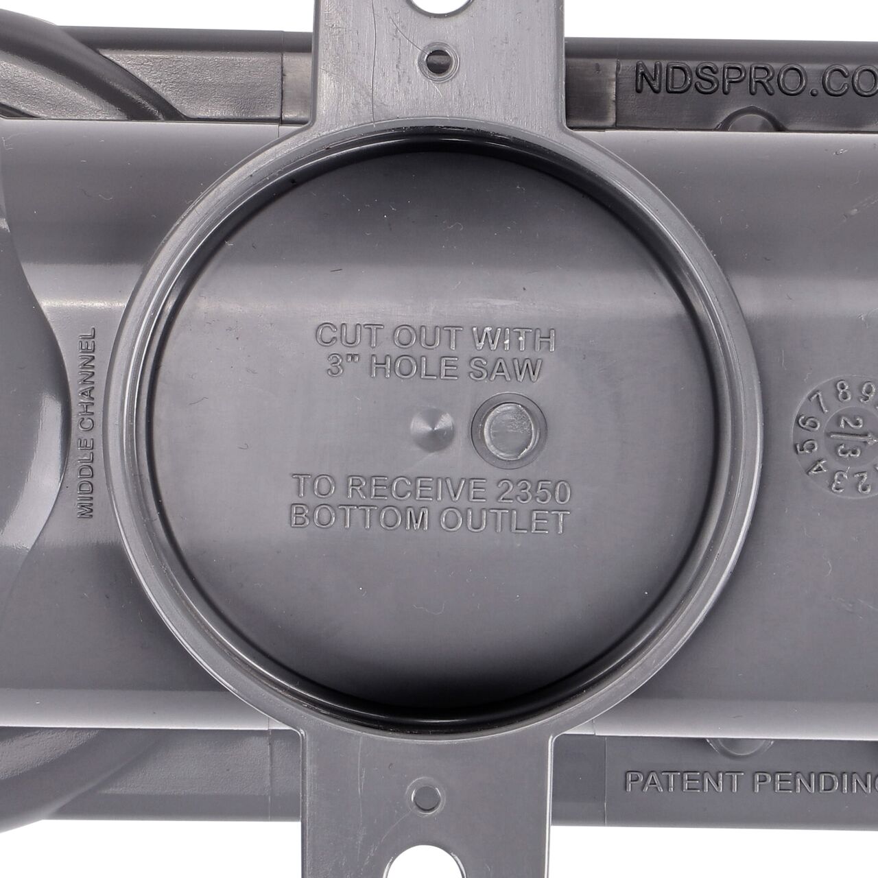 Closeup of the bottom view of the circular cutline to add a Spee-D bottom outlet that connects to 3 in. and 4 in. S&D fittings on the Spee-D® Contour™ Channel Drain Middle Section and Gray Grate (NDS 400-ACM-WH)