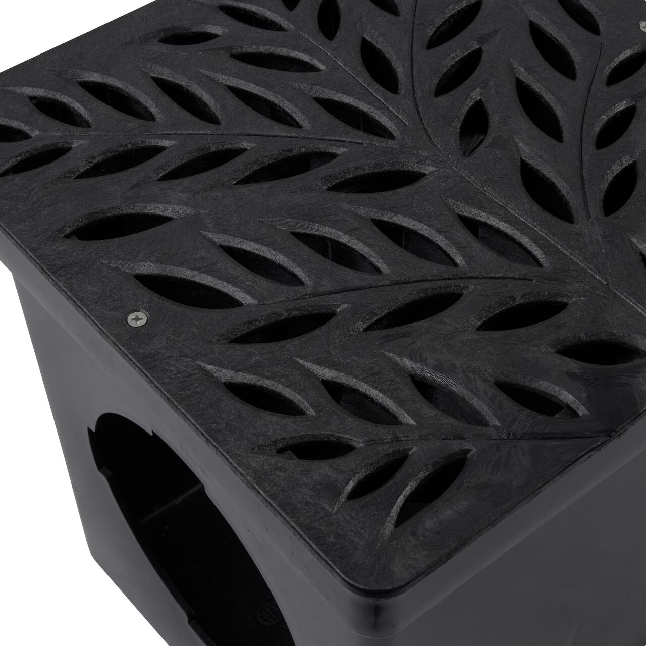 Closeup shot of NDS 12 in. Square Catch Basin Drain Grate, Decorative Botanical Design, Black Plastic (NDS 1218) and how it fits securely within a 12 in. Square Catch Basin Drain with 2 Openings (NDS 1200*); retail