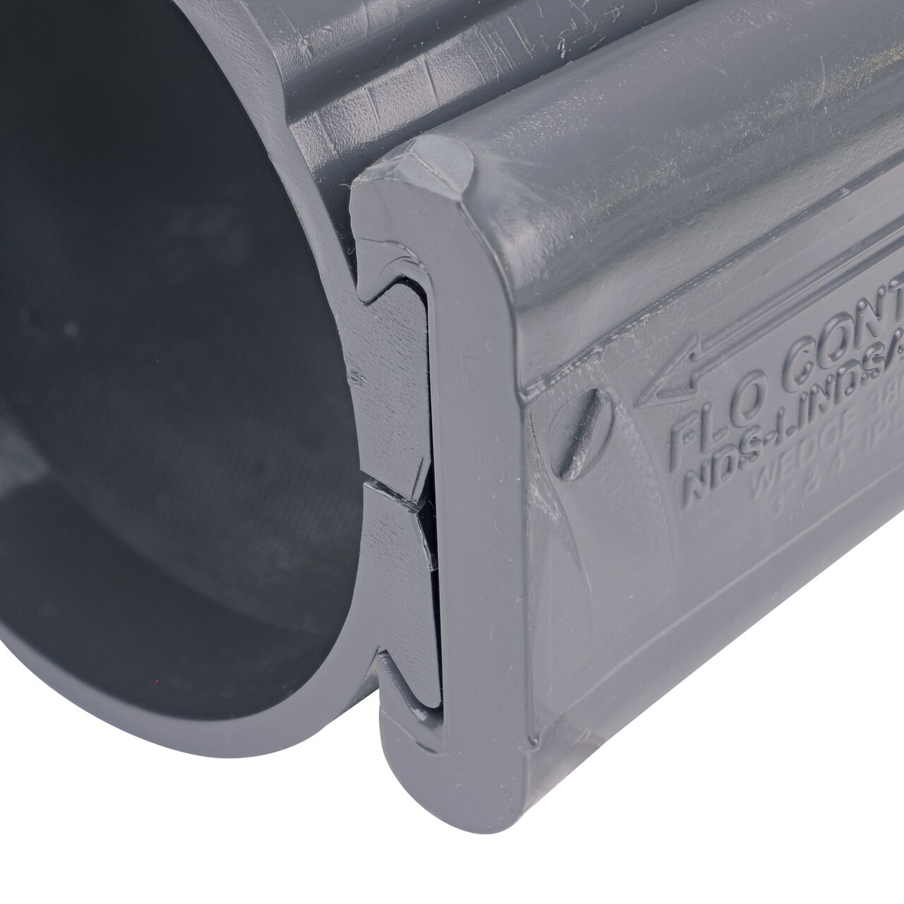 Closeup of the wedge installed securely on the NDS Clamp-It™ Rigid PVC Saddle with 1-1/2 in. slip connection on top (NDS 454015) for 4 in. PVC pipe
