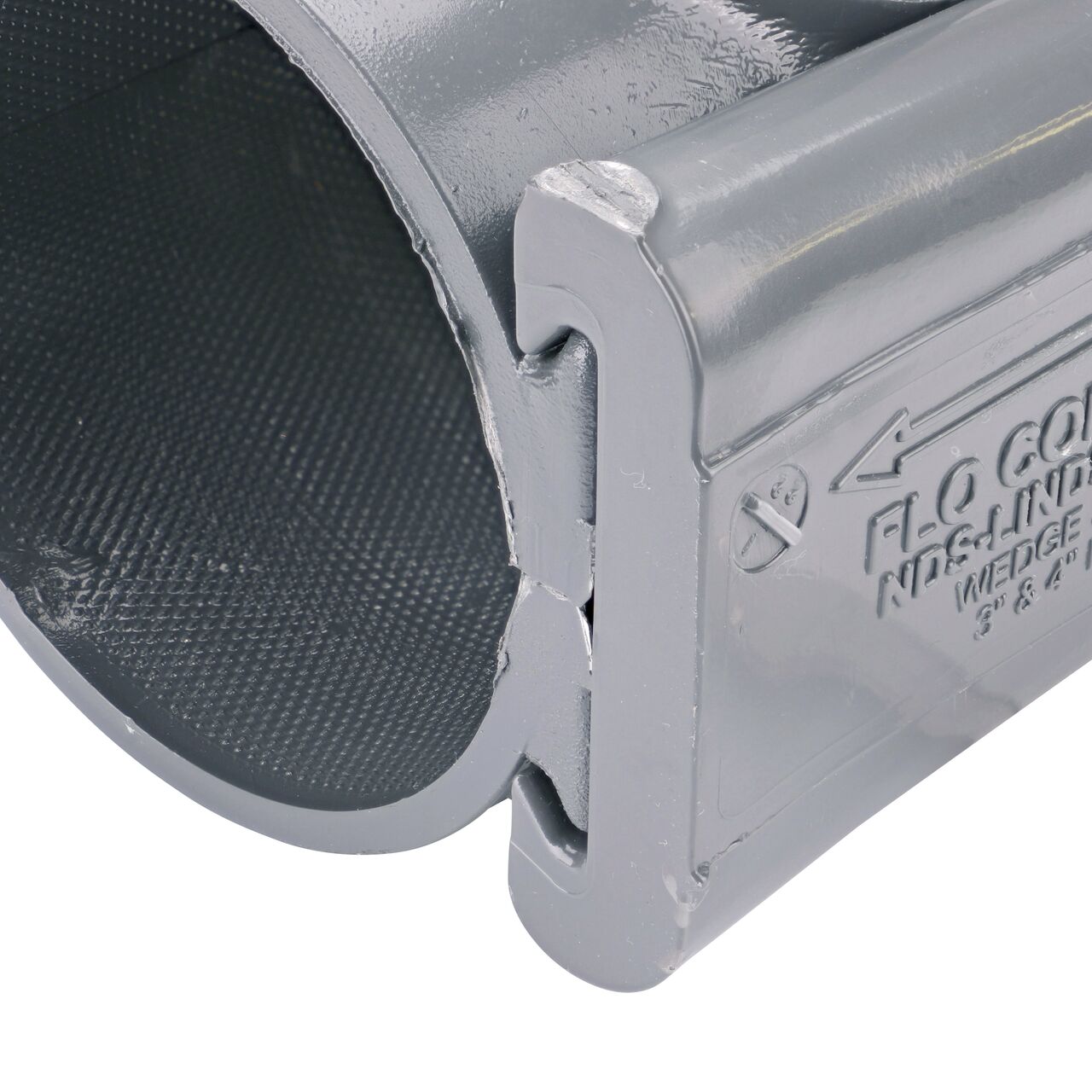 Closeup of the wedge installed securely on the NDS Clamp-It™ Rigid PVC Saddle with 2 in. slip connection on top (NDS 453020) for 3 in. PVC pipe