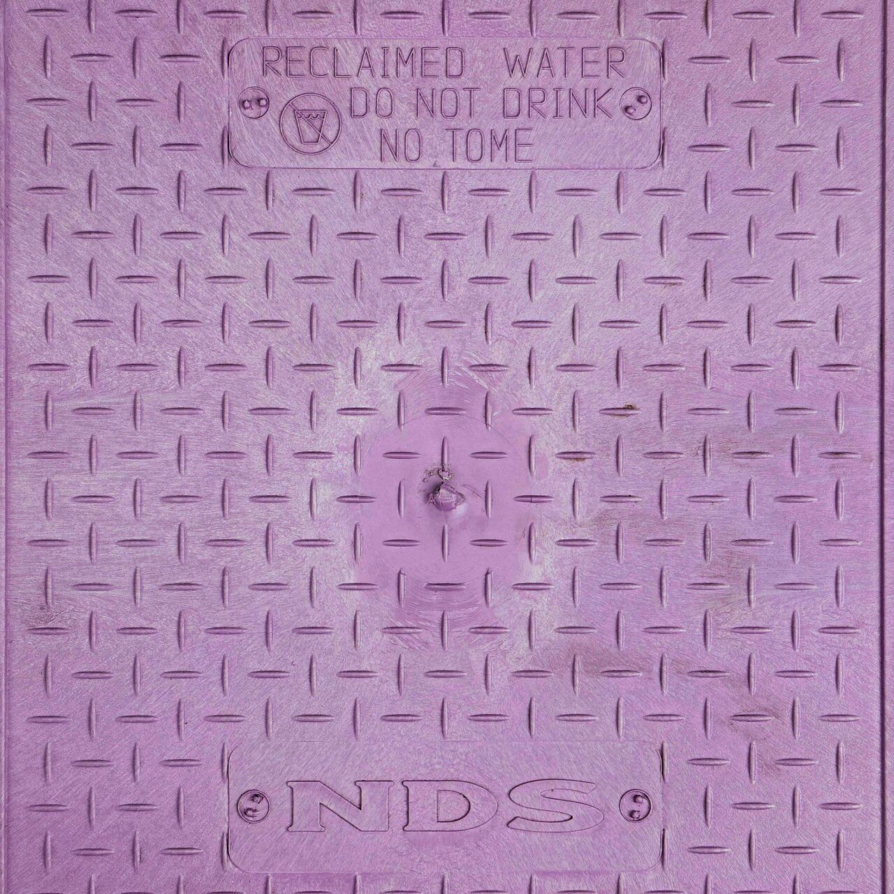 Closeup view of the Reclaimed Water markings on the Purple Reclaimed Water cover for the NDS 14 X 19 in. Rectangular Standard Series Valve Box (NDS 115BCR)