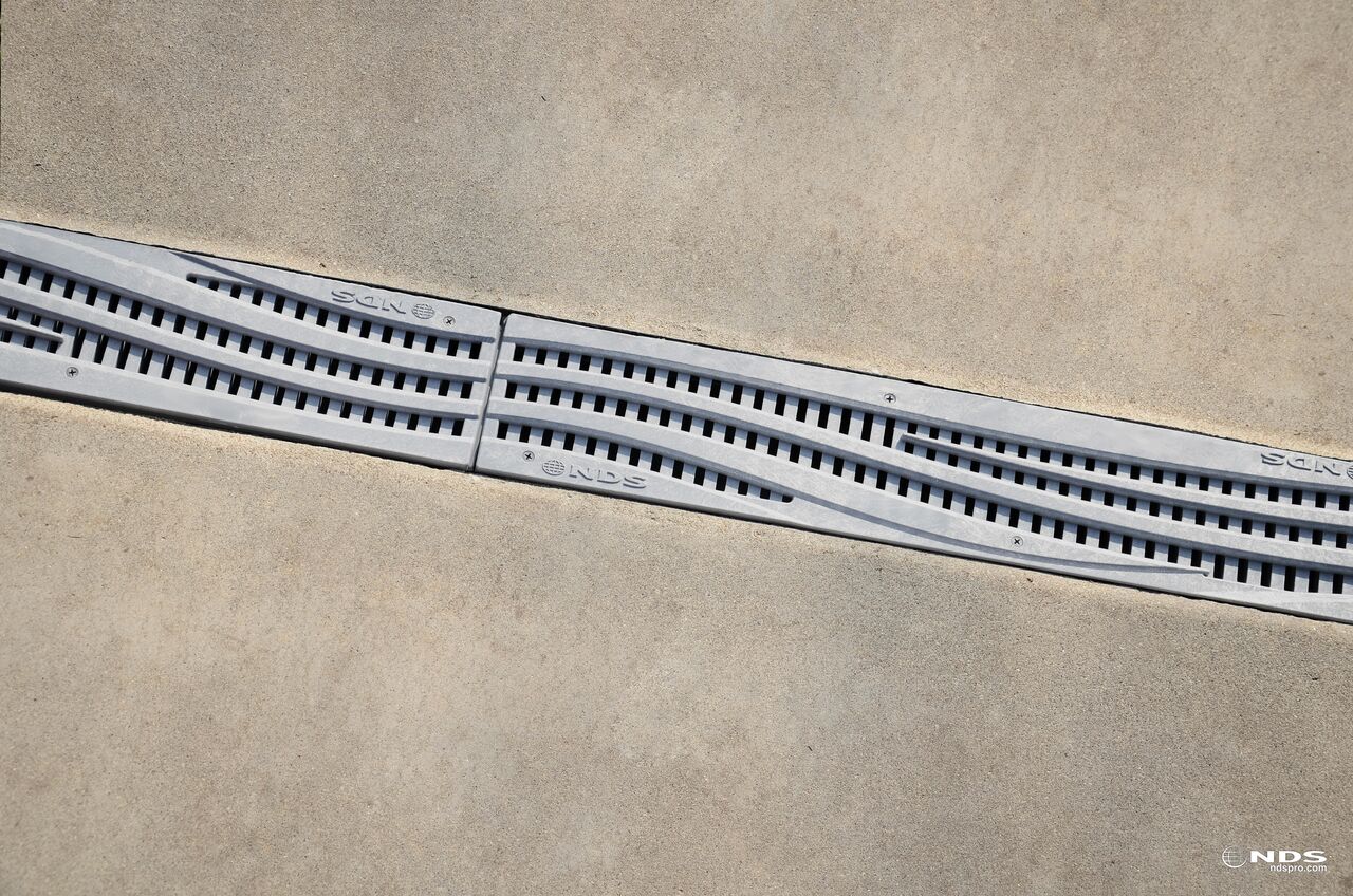 NDS Spee-D® Channel Drain Grate with Decorative Wave Design in Gray Plastic installed to drainage system (NDS 253GYRTL, NDS 253GY)