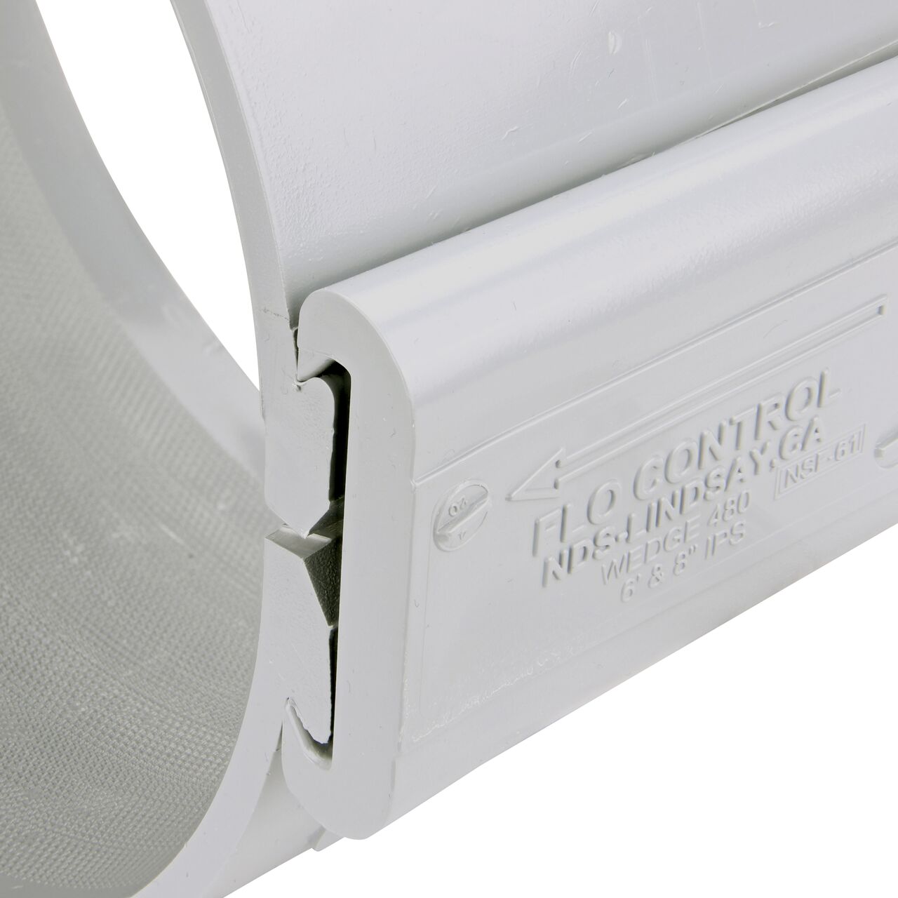 Closeup of the wedge installed securely on the NDS Clamp-It™ Rigid PVC Saddle with 1-1/2 in. slip connection on top (NDS 458015) for 8 in. PVC pipe