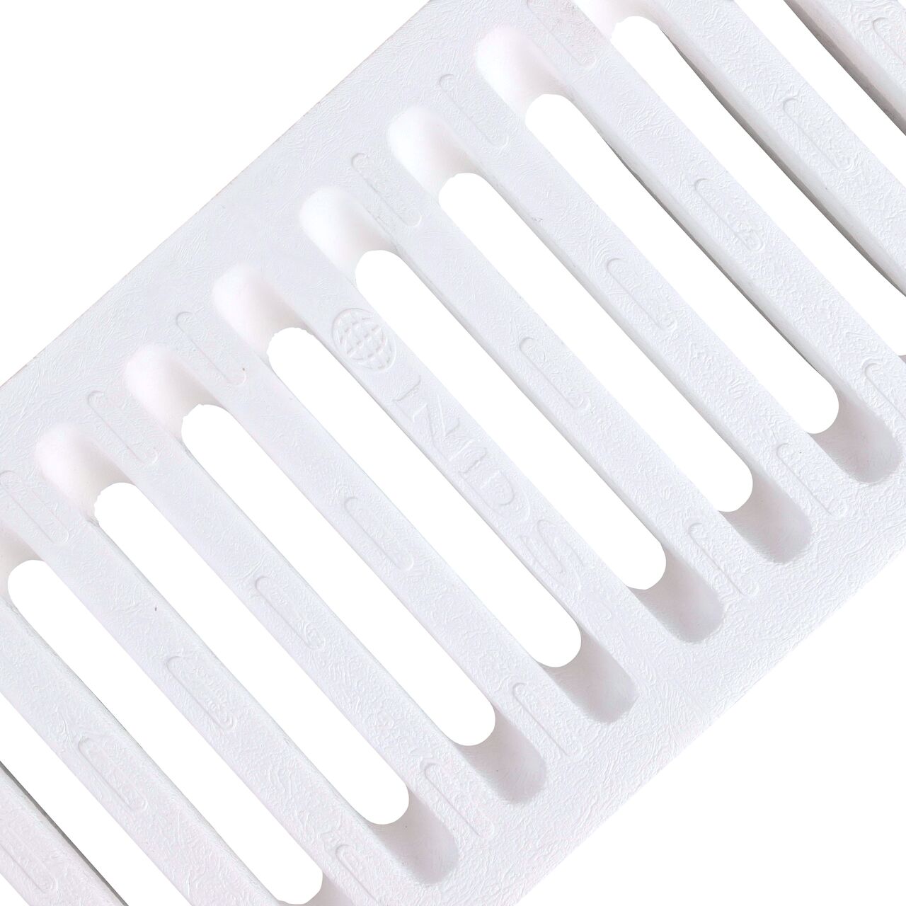 Angled View of the white plastic Dura Slope™ Channel Drain Grate (NDS 660) perforated design
