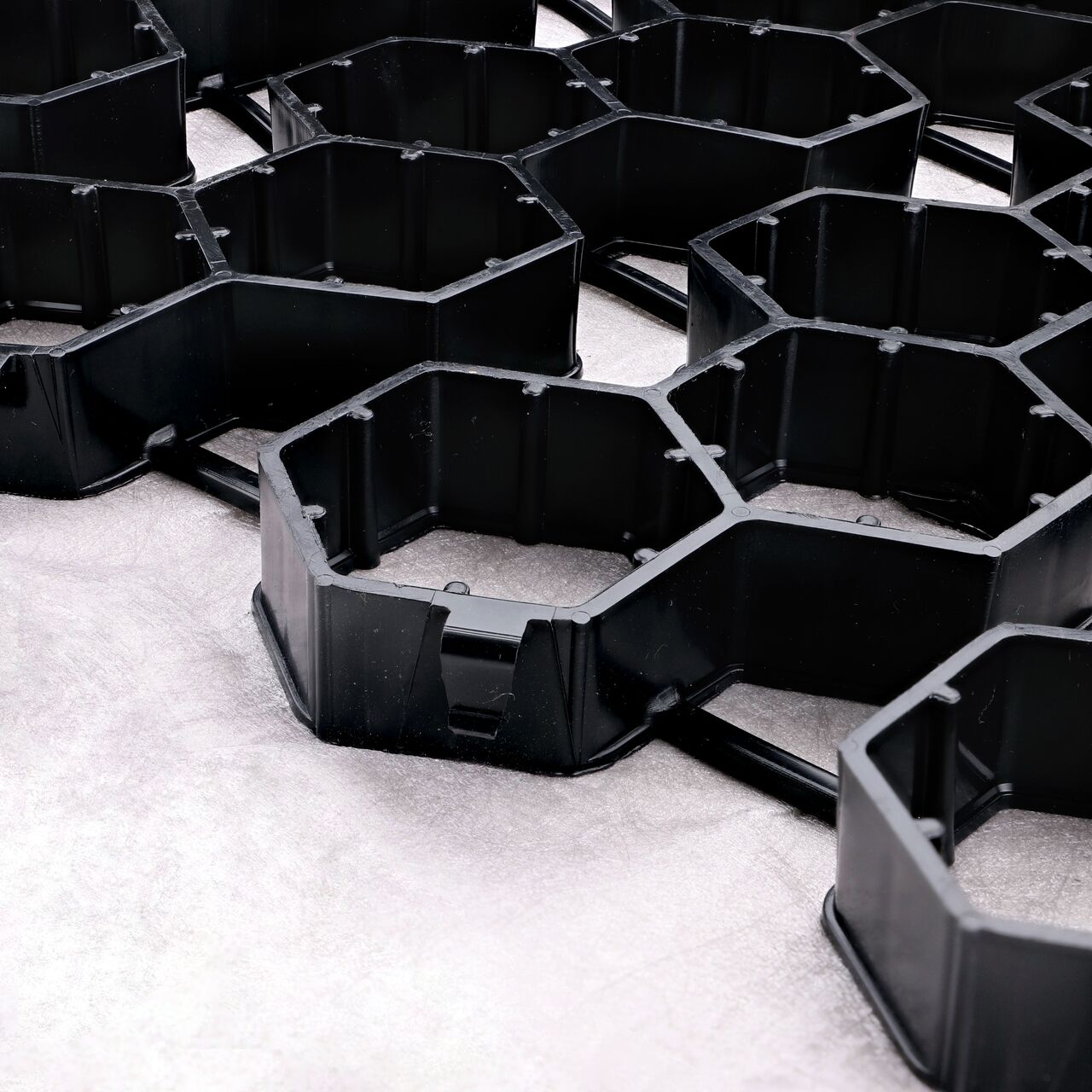 Closeup View of the side by side top-down locking tabs on the Black NDS EZ Roll® Gravel Pavers (NDS GP4X150)