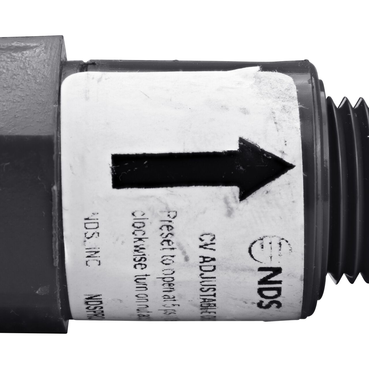Closeup of the label marking the flow of water of the NDS Gray 1/2 in. IPS FPT X MPT PVC Adjustable Inline Spring Check Valve (NDS CV-0500-FM)