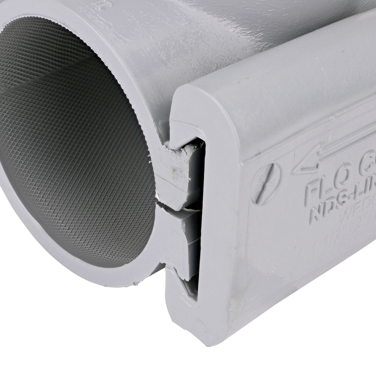 Closeup of the wedge installed securely on the NDS Clamp-It™ Rigid PVC Saddle with 1-1/2 in. FPT connection on top (NDS 422015) for 2 in. PVC pipe