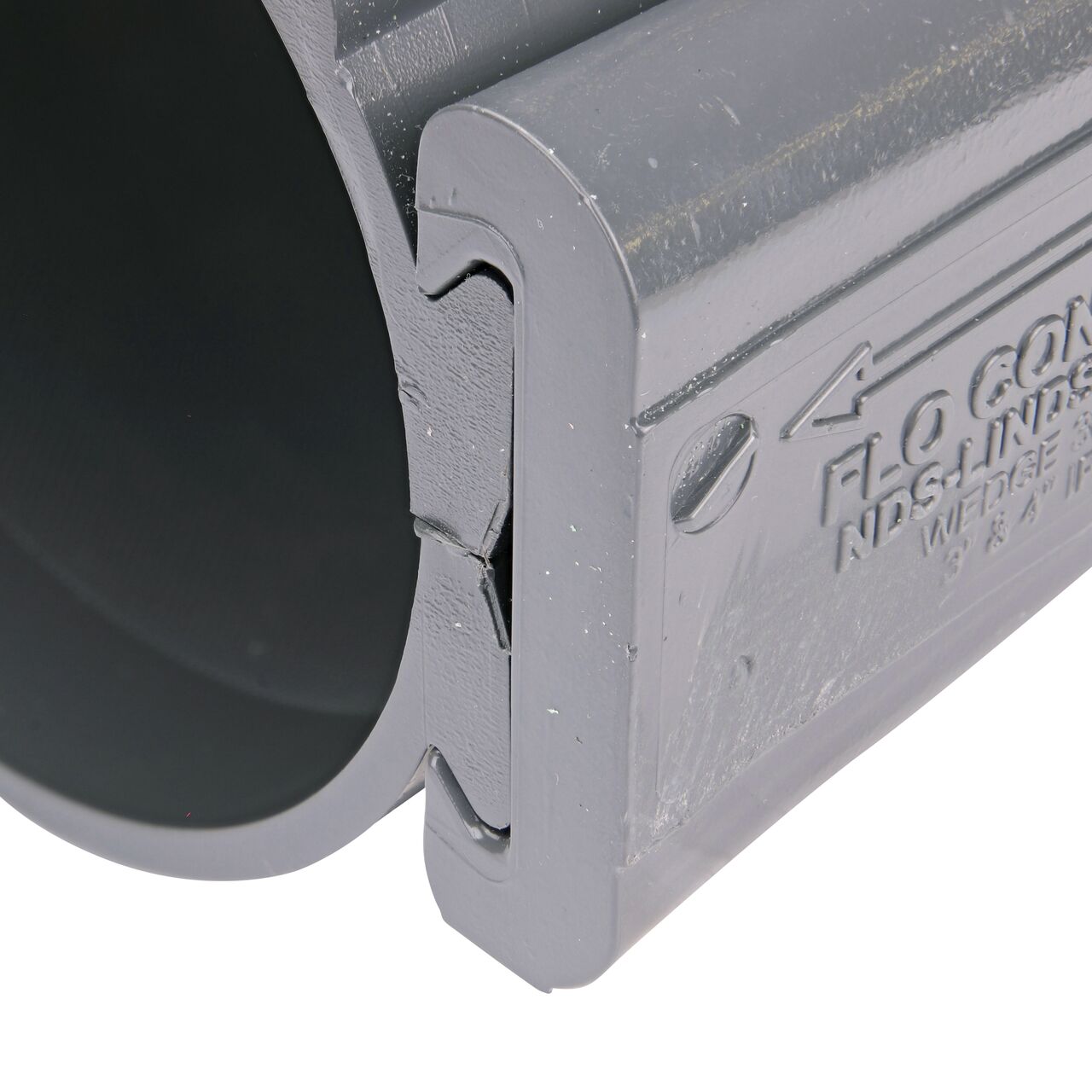 Closeup of the wedge installed securely on the NDS Clamp-It™ Rigid PVC Saddle with 3/4 in. FPT connection on top (NDS 444007) for 4 in. PVC pipe
