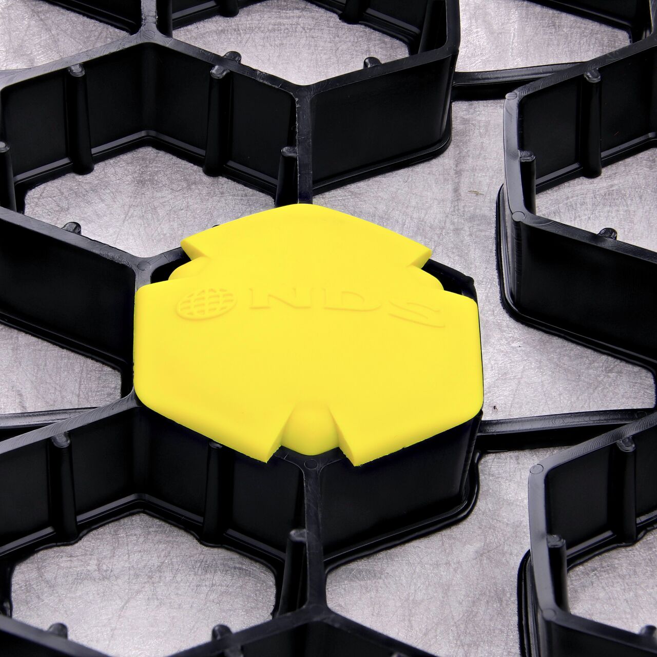 Closeup of one Yellow NDS EZ Marker™ Parking Delineators (NDS EZMARKER) installed in the NDS EZ Roll® Gravel Pavers (NDS GP4X150)