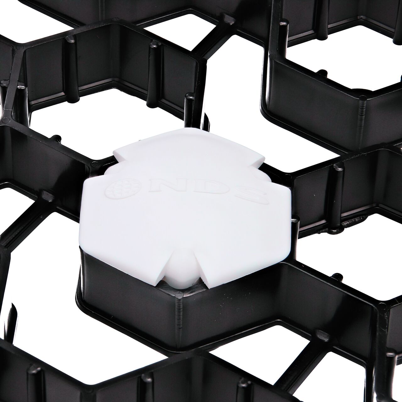 Closeup of one White NDS EZ Marker™ Parking Delineators (NDS EZMARKER) installed in the NDS EZ Roll® Grass Pavers