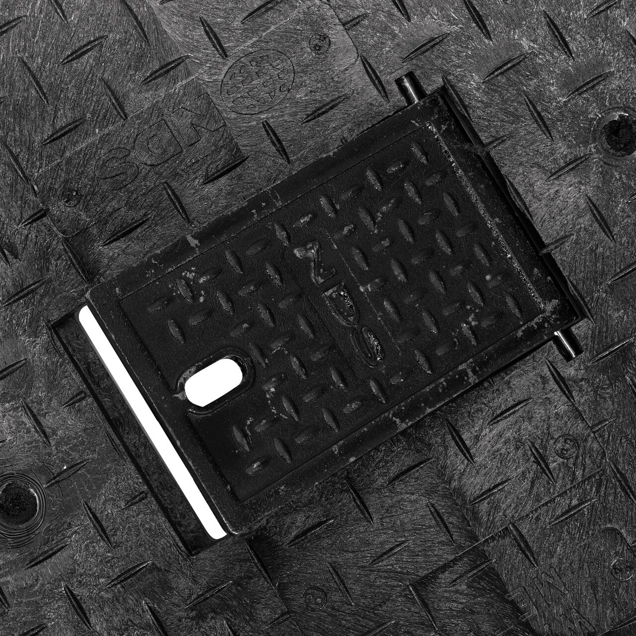 Close up view of the hinged side of the Cast Iron reader door on the NDS 17 in. X 30 in. Rectangular Pro Series Meter Cover which allows for easy Meter reading (NDS 123CDMCIF)