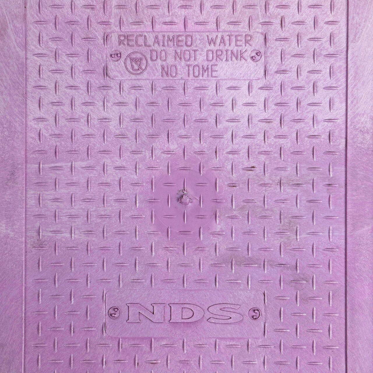 Closeup view of the Reclaimed Water markings on the Purple Reclaimed Water cover (NDS 113CR) for the NDS 14 X 19 in. Rectangular Standard Series Valve Box