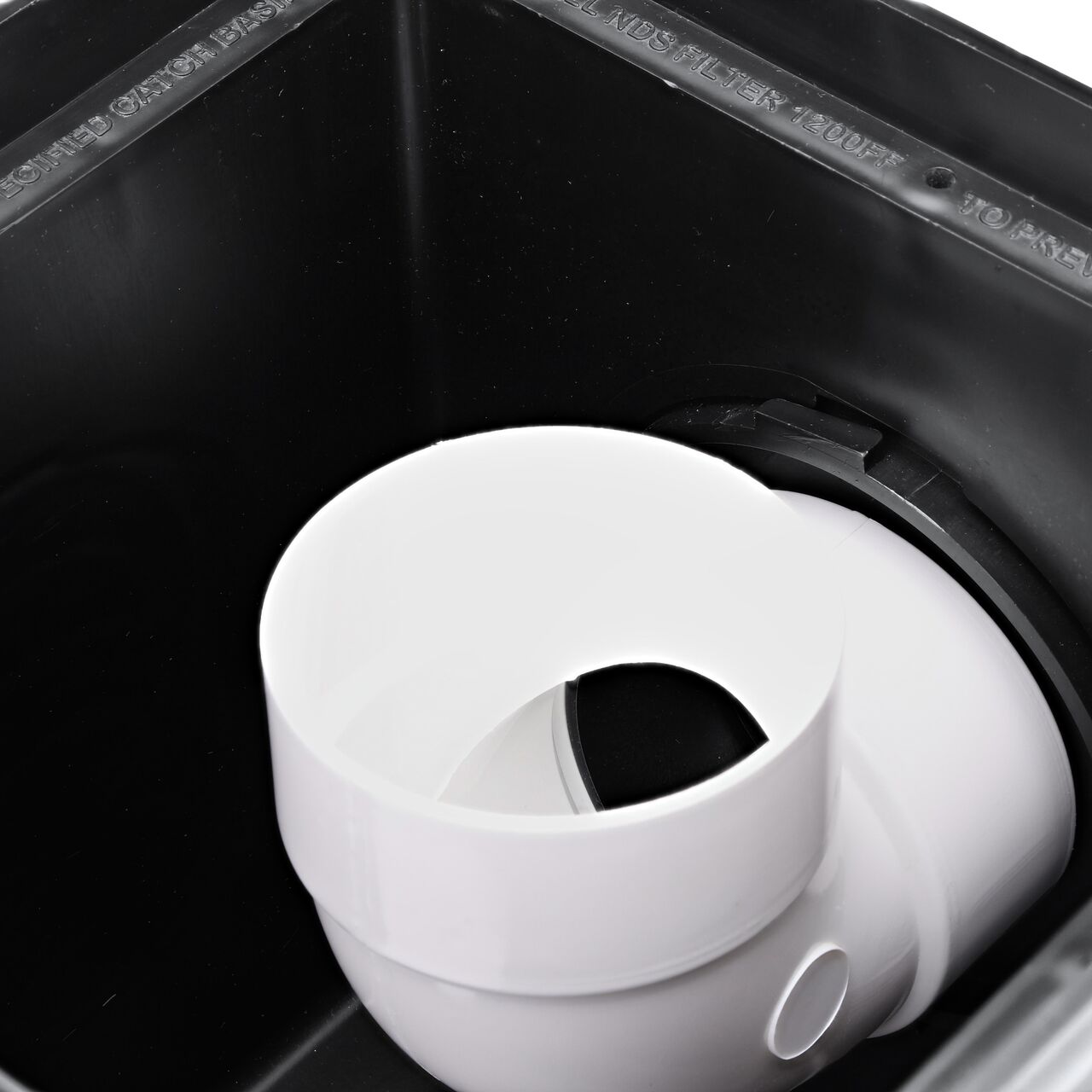 The inside view of the NDS Outlet Adapter with Internal Spigot for adjustable invert height (NDS 1242) installed on a 12 in. Catch Basin Drain (NDS 1200) with a S&D Fitting attached turned upward