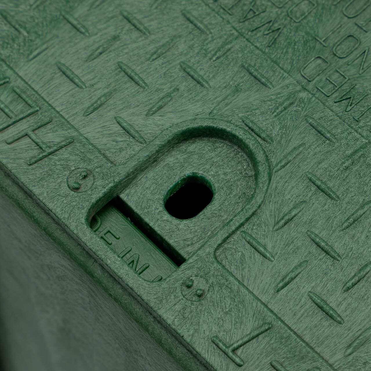Closeup view of the traditional bolt hole on the Green NDS 14 in. X 19 in. Rectangular Pro-Spec® Series Valve Box (NDS 314BCBRG) for securing valve lid or cover to the valve box