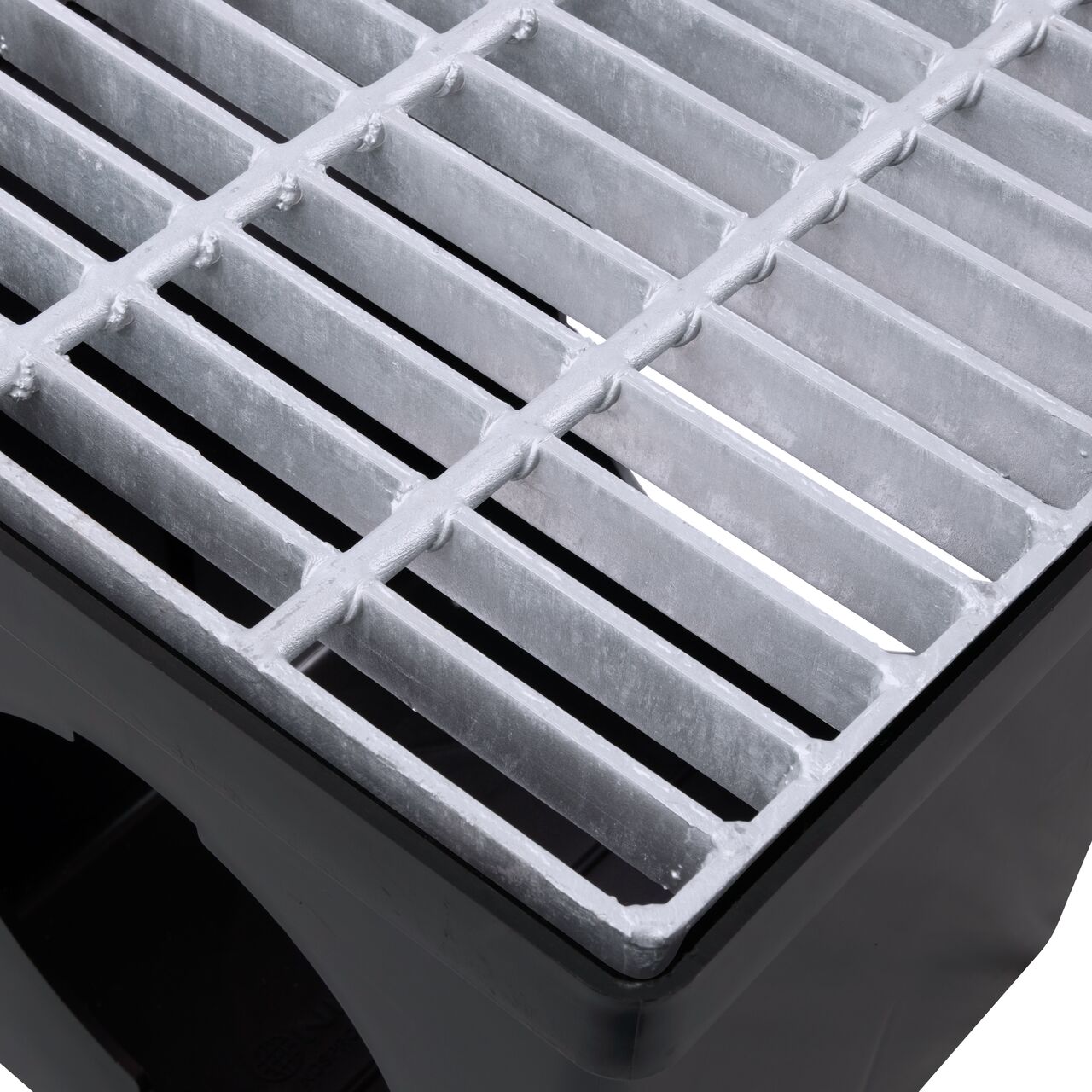 Closeup view of the 12 in. Galvanized Steel Grate (NDS 1215) installed on a black plastic 12 in. Catch Basin Drain with 2 Openings (NDS 1200*); retail