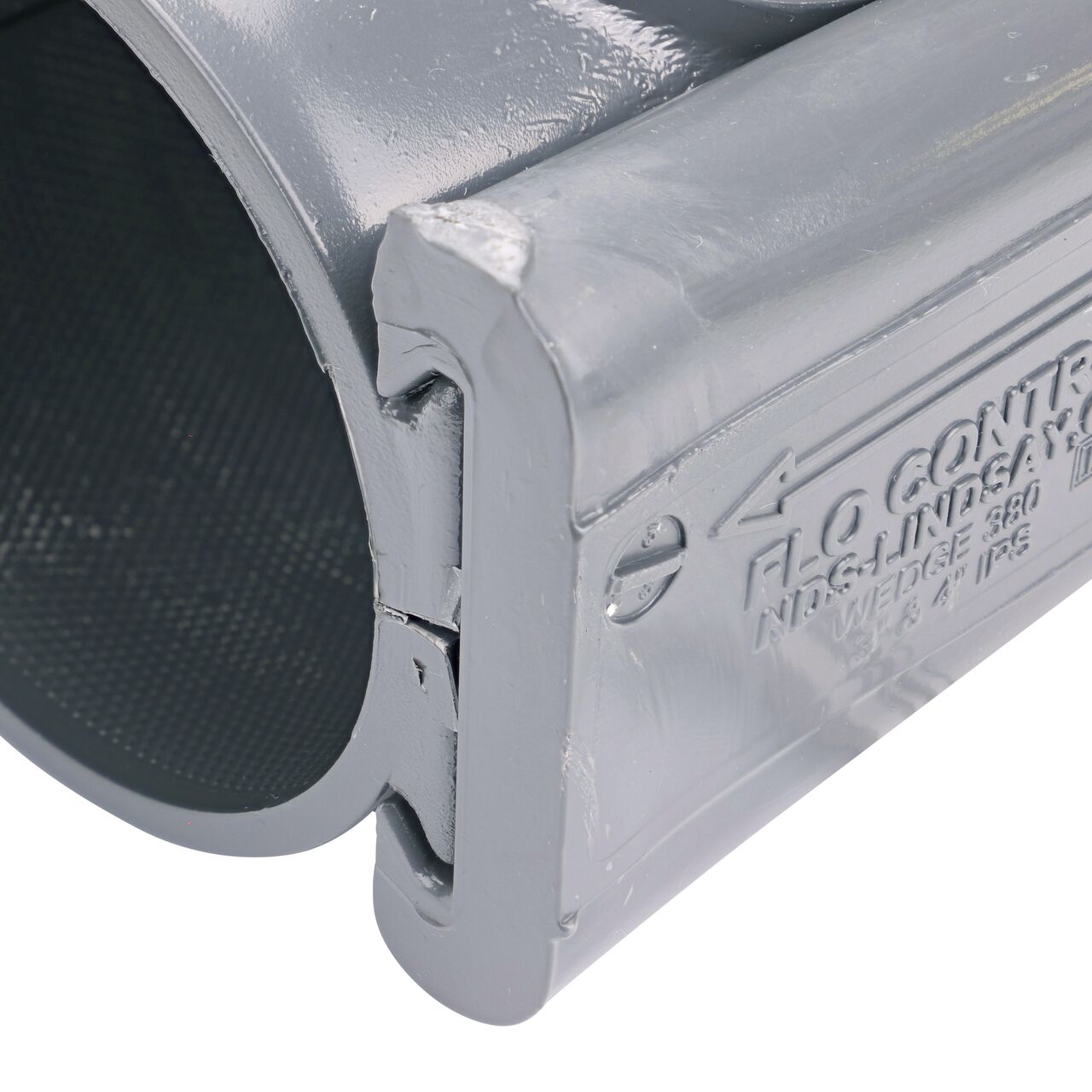 Closeup of the wedge installed securely on the NDS Clamp-It™ Rigid PVC Saddle with 1 in. slip connection on top (NDS 453010) for 3 in. PVC pipe