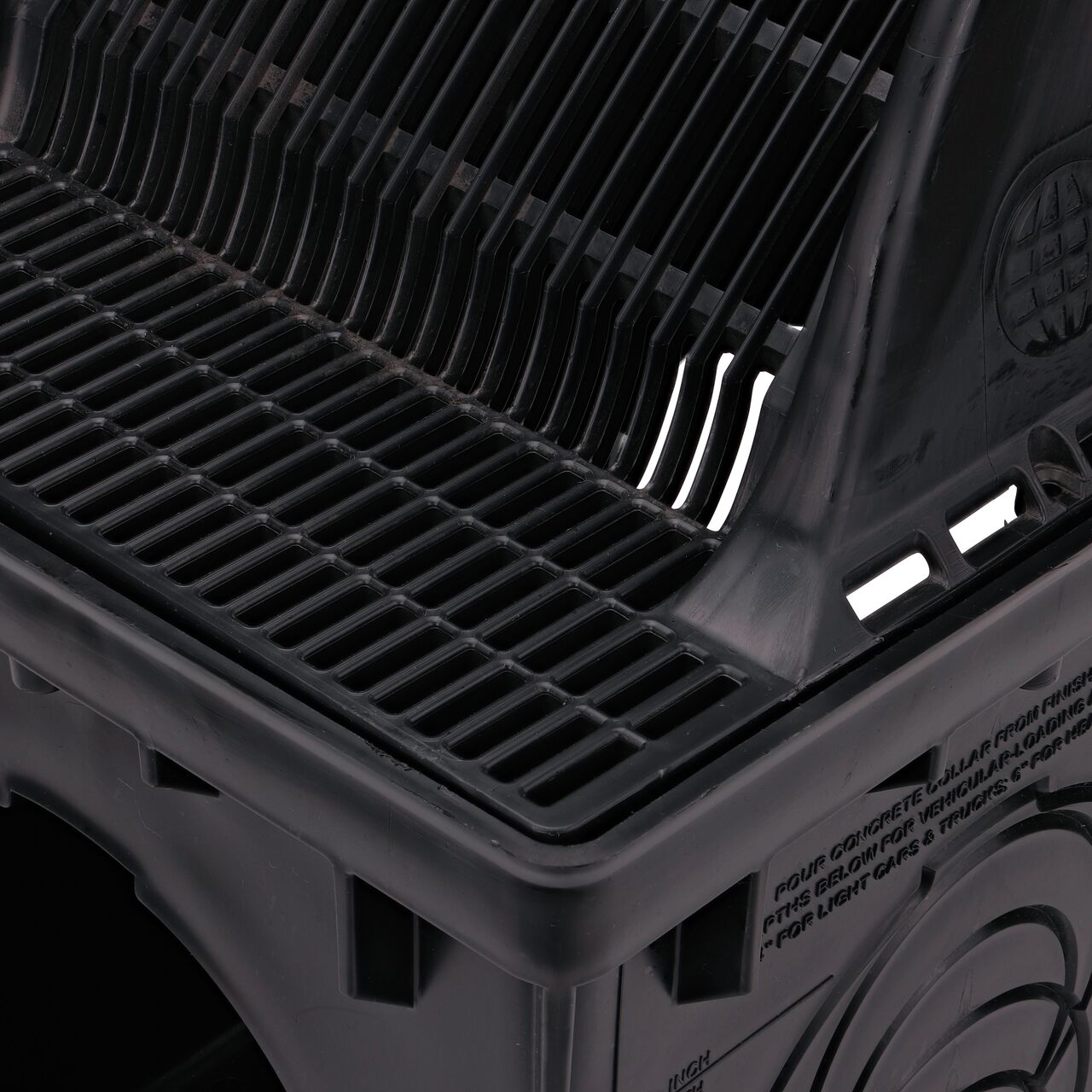 Closeup view of 12 in. Square Catch Basin Downspout Grate (NDS 1200DSG) as it sits on a NDS 12 in. catch basin drain, highlighting angle, shelf in front, Splashguard on side with side holes to fasten down