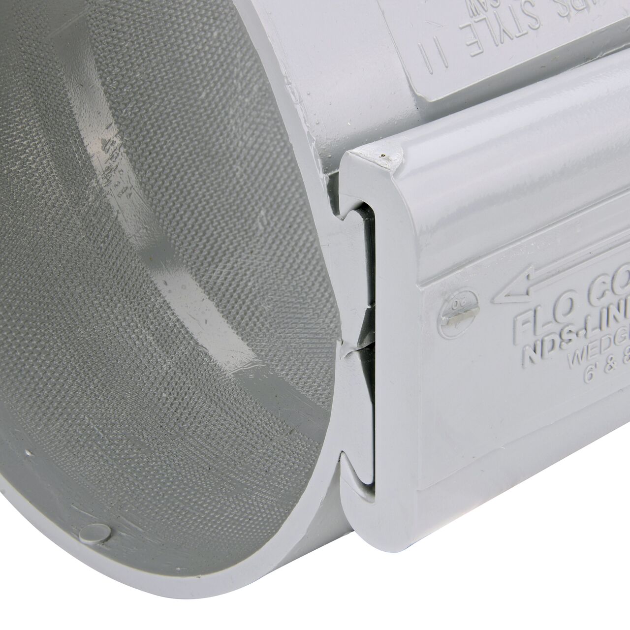Closeup of the wedge installed securely on the NDS Clamp-It™ Rigid PVC Saddle with 1-1/2 in. slip connection on top (NDS  456015) for 6 in. PVC pipe