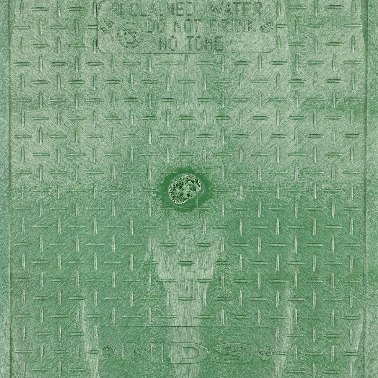 Closeup view of the Reclaimed Water markings on the Green Reclaimed Water cover (NDS 313CRG) for the NDS 14 in. X 19 in. Rectangular Pro-Spec® Series Valve Box