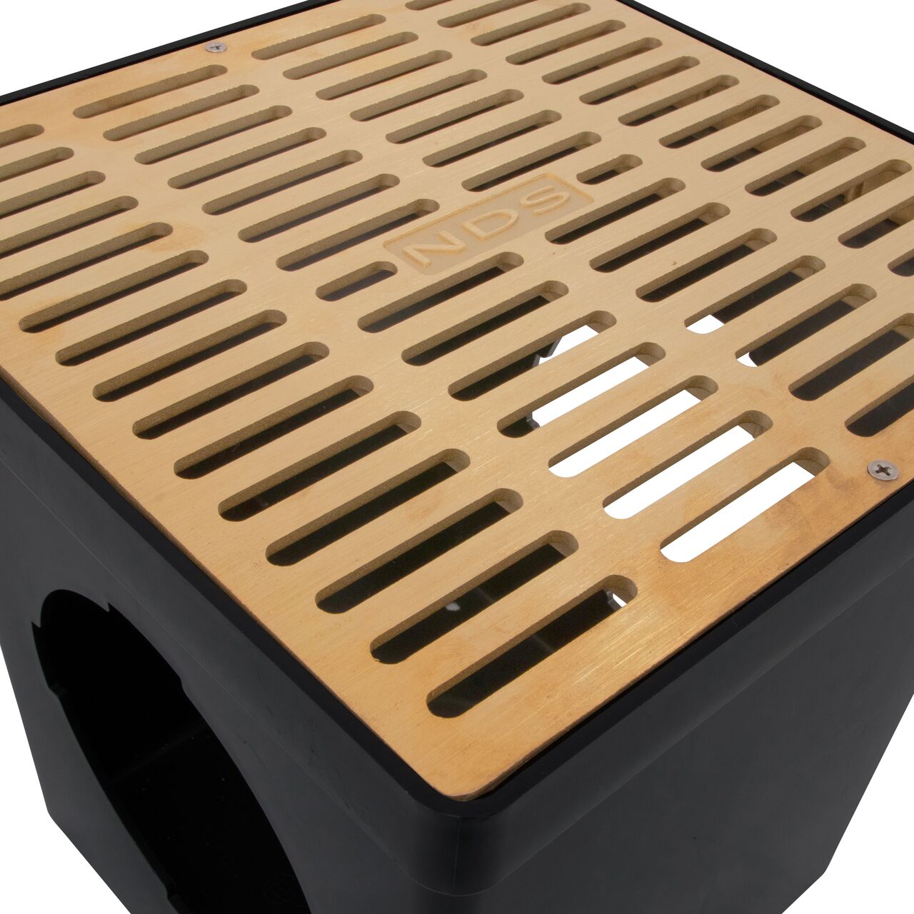 Closeup view of the 12 in. Brass Metal Grate (NDS 1230B) installed on a black plastic 12 in. Catch Basin Drain with 2 Openings (NDS 1200*); retail