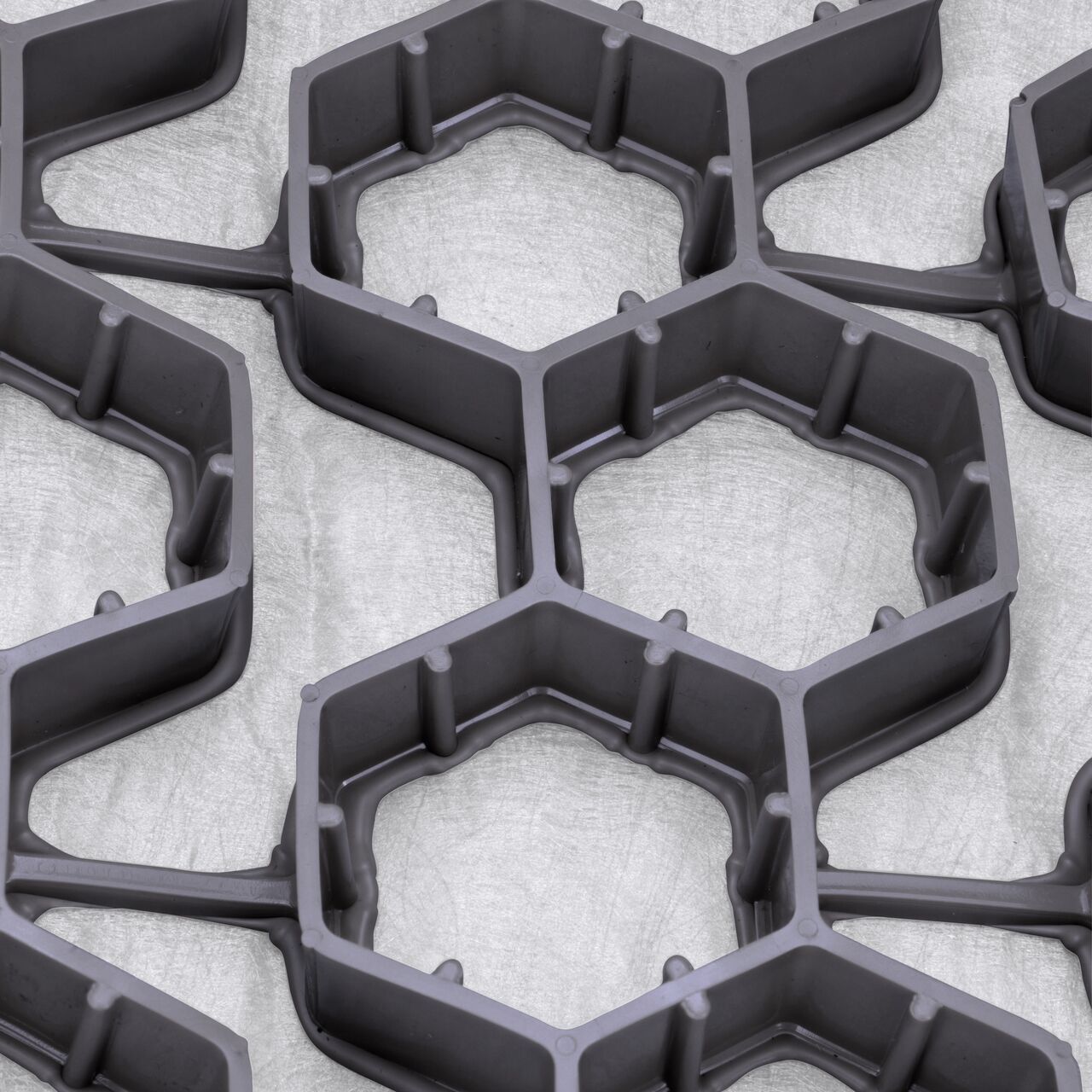 Closeup view of the interconnected hexagonal cells with shared walls which provide strength in the Gray NDS EZ Roll® Gravel Pavers (NDS GP4X150G)