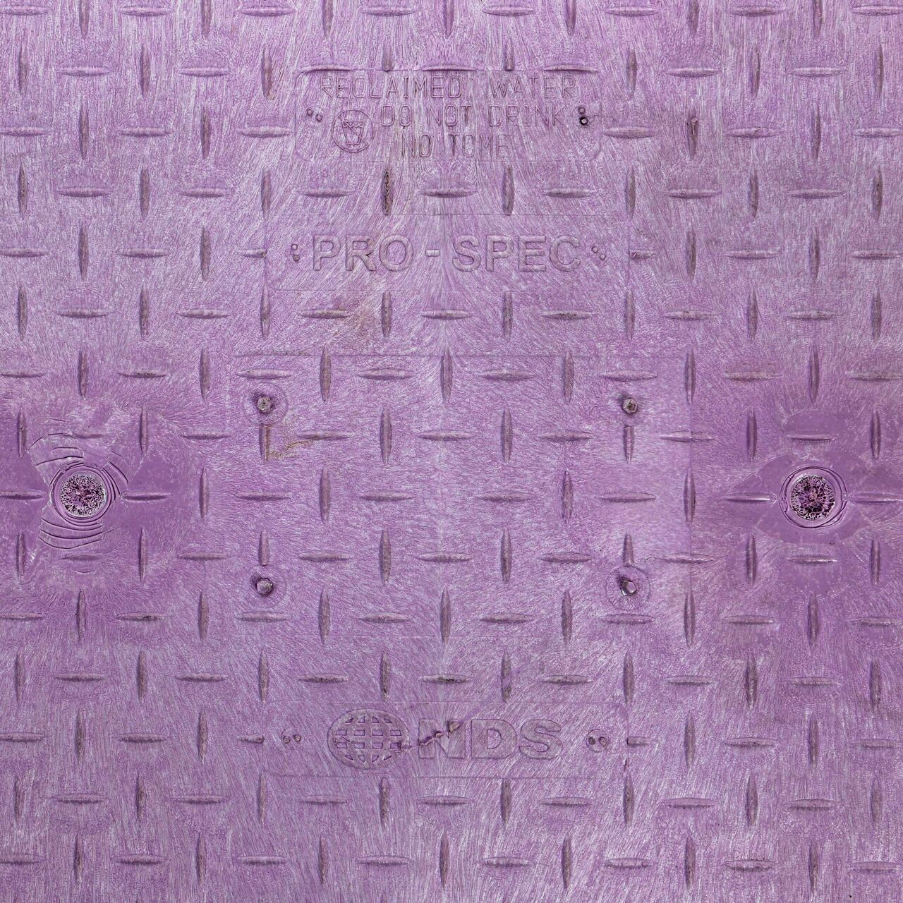Closeup view of the Reclaimed Water markings on the Purple Reclaimed Water cover (NDS 323CR) for the NDS 17 in. X 30 in. Rectangular Pro-Spec® Series Valve Box