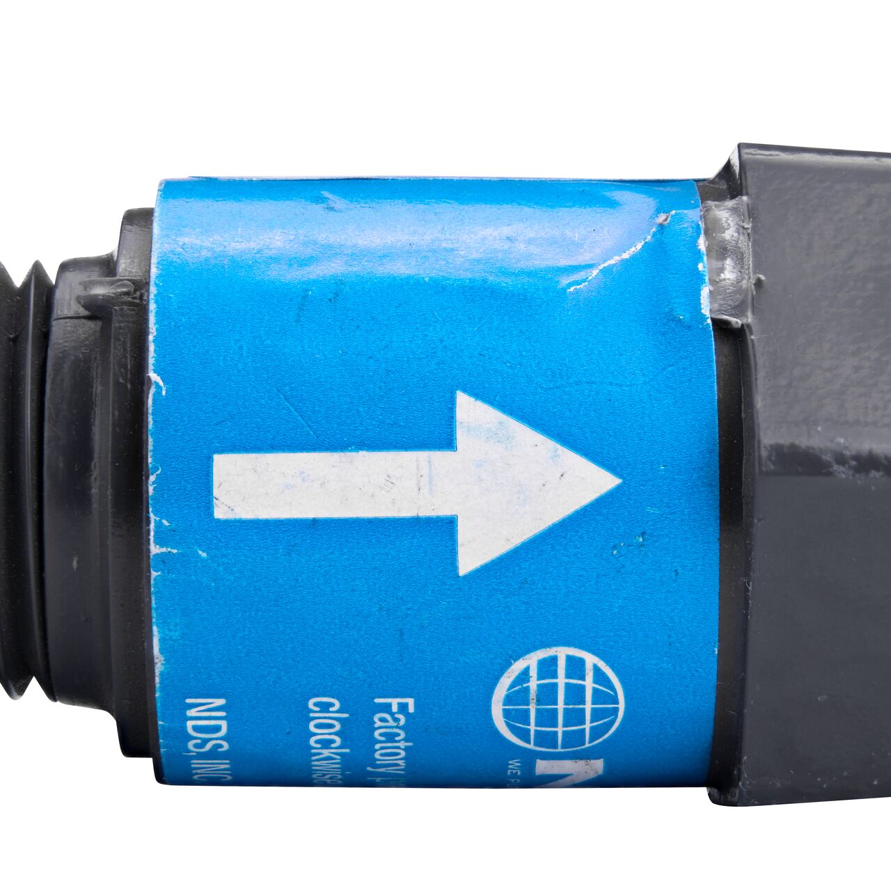 Closeup of the label marking the flow of water of the NDS Gray 1/2 in. IPS MPT X FPT PVC Adjustable Inline Spring Check Valve (NDS CV-0500-MF)