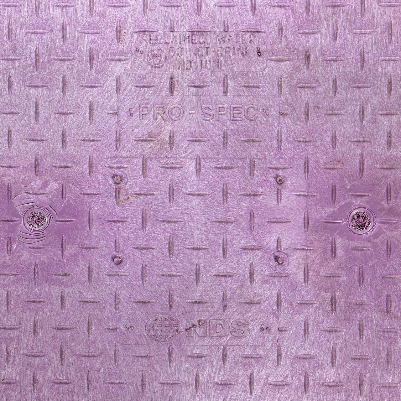 Closeup view of the Water markings on the Purple Water cover for the NDS 17 in. X 30 in. Rectangular Pro-Spec® Series Valve Box (NDS 326PBCBR)