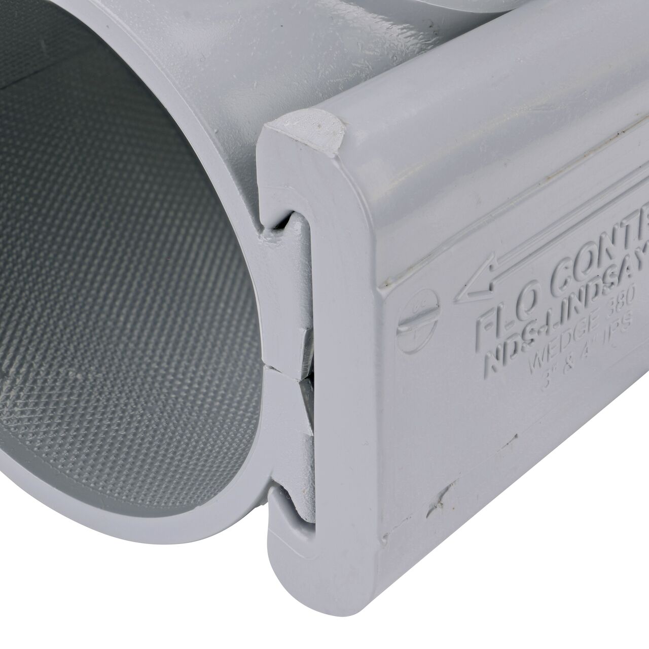 Closeup of the wedge installed securely on the NDS Clamp-It™ Rigid PVC Saddle with 2 in. FPT connection on top (NDS 443020) for 3 in. PVC pipe