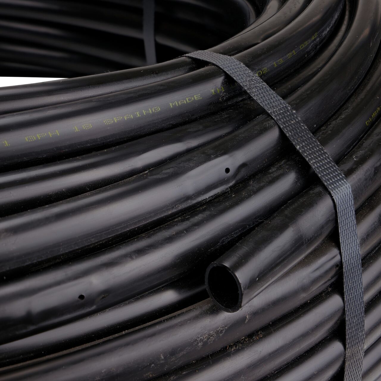 Closeup of the end of the NDS 500 ft. Black Tubing with 1.0 GPH Pressure Compensating Emitters with 12 in. Spacing to show how to pull out the dripline  (NDS SFPC-BL-6418-05)