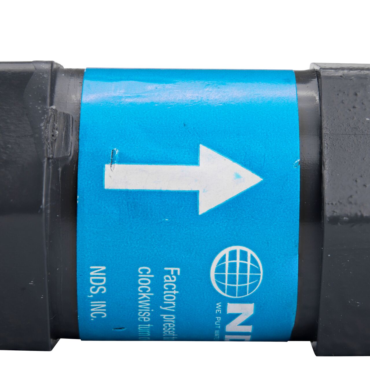 Closeup of the label marking the label flow of the NDS Gray 3/4 in. IPS FPT X FPT PVC Adjustable Inline Spring Check Valve (NDS CV-0750-FF)