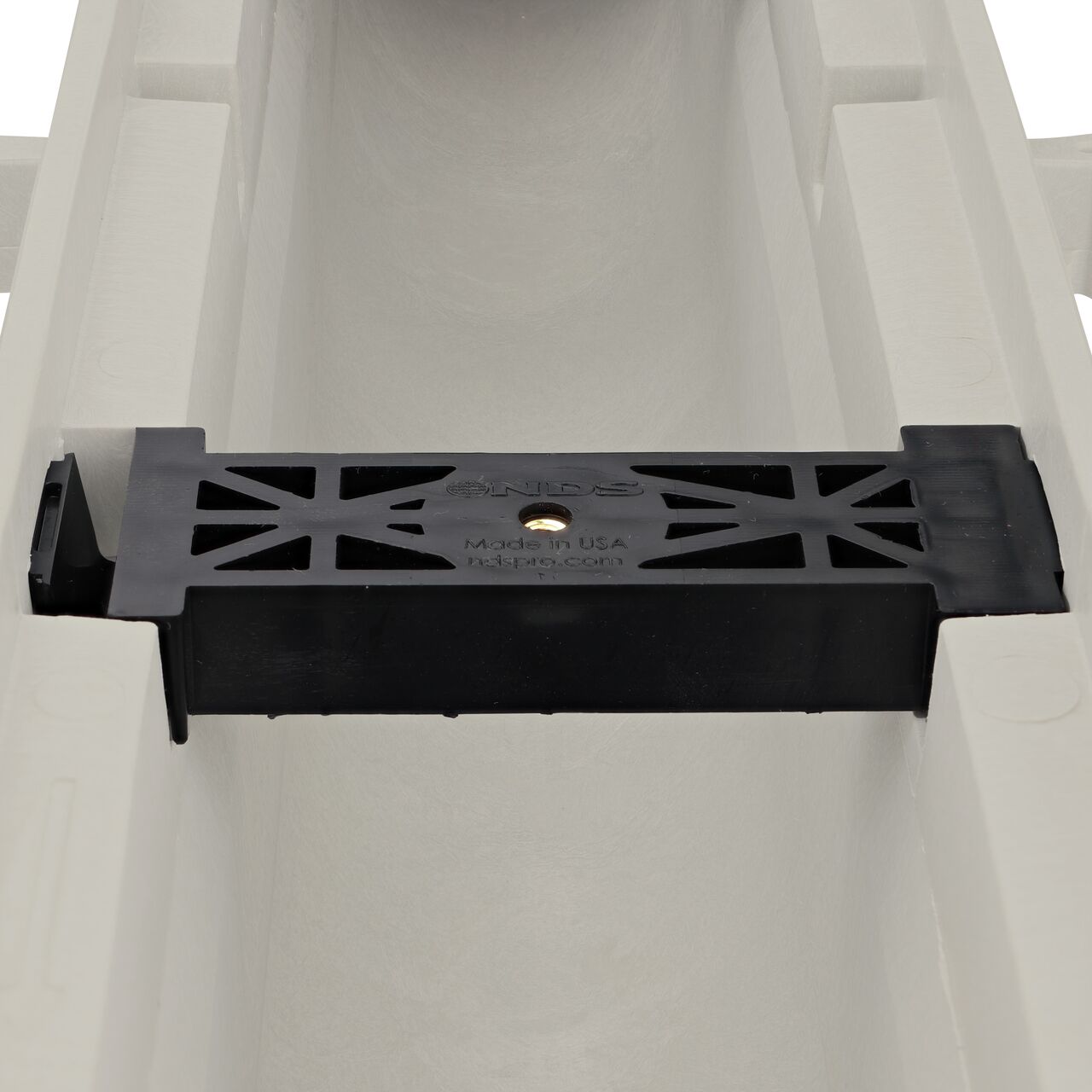 Closeup view of the grate locking system on the NDS Dura Slope Channel Drain, which locks grate to the integral frame (NDS DS-097N)