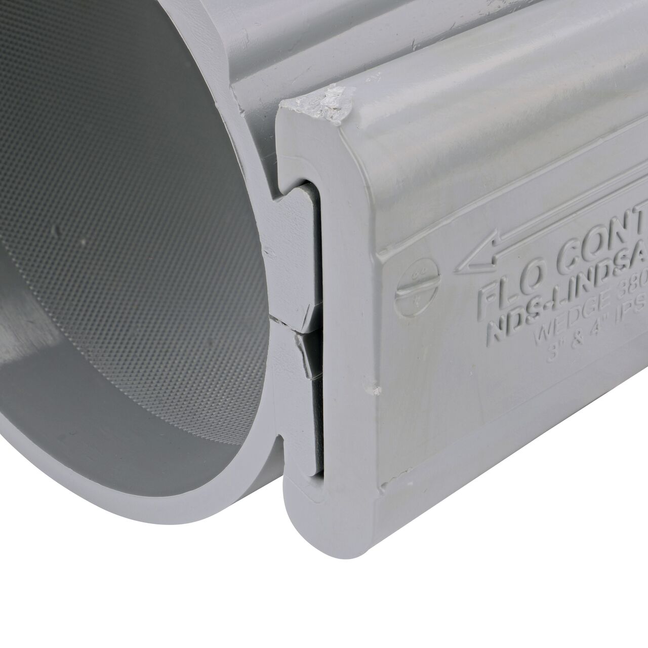 Closeup of the wedge installed securely on the NDS Clamp-It™ Rigid PVC Saddle with 2 in. slip connection on top (NDS 454020) for 4 in. PVC pipe