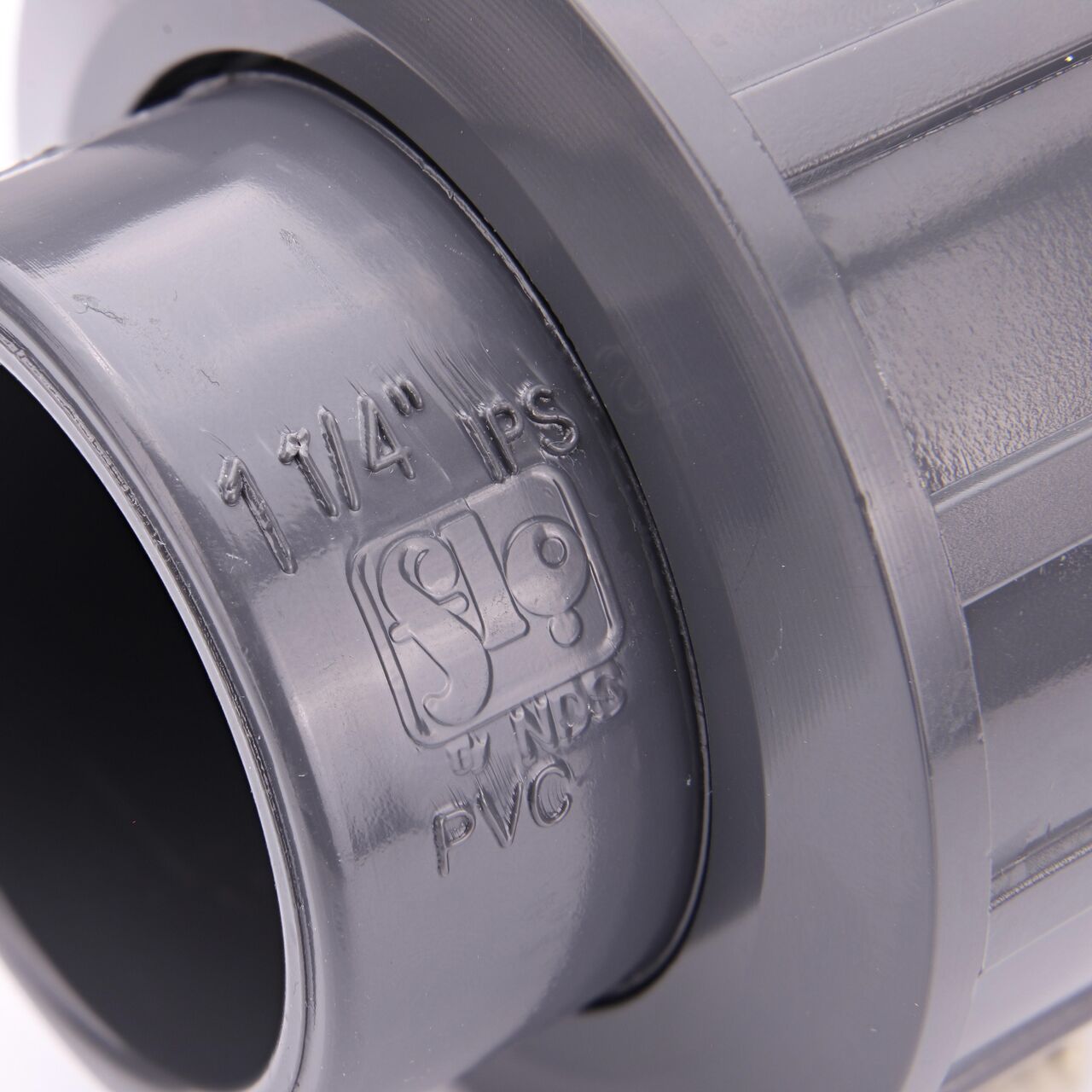 Closeup view of the NDS 1-1/4 in. PVC Union shows each end is labeled that it connects to 1-1/4 in. Schedule 80 pipe for residential, commercial, and industrial applications (NDS U-1250-S)