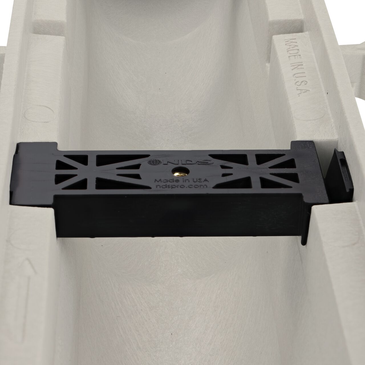 Closeup view of the grate locking system on the NDS Dura Slope Channel Drain, which locks grate to the integral frame (NDS DS-094N)